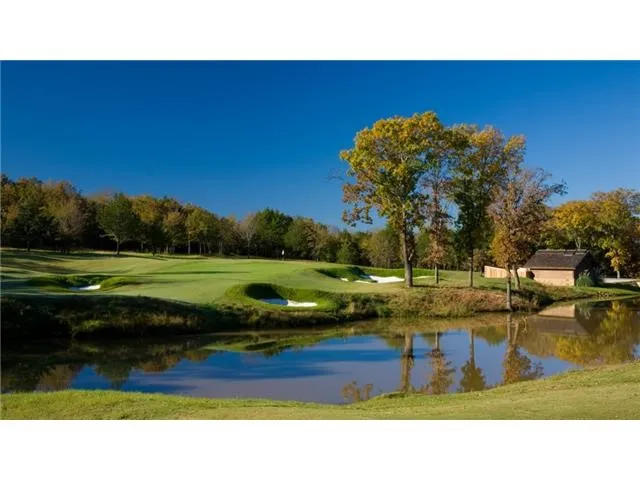 View of home's community with a water view, a lawn, view of golf course, and view of wooded area