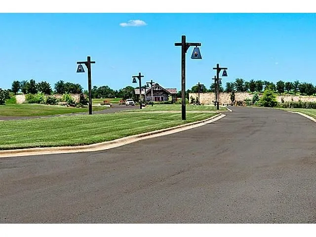 View of asphalt street with street lights and curbs