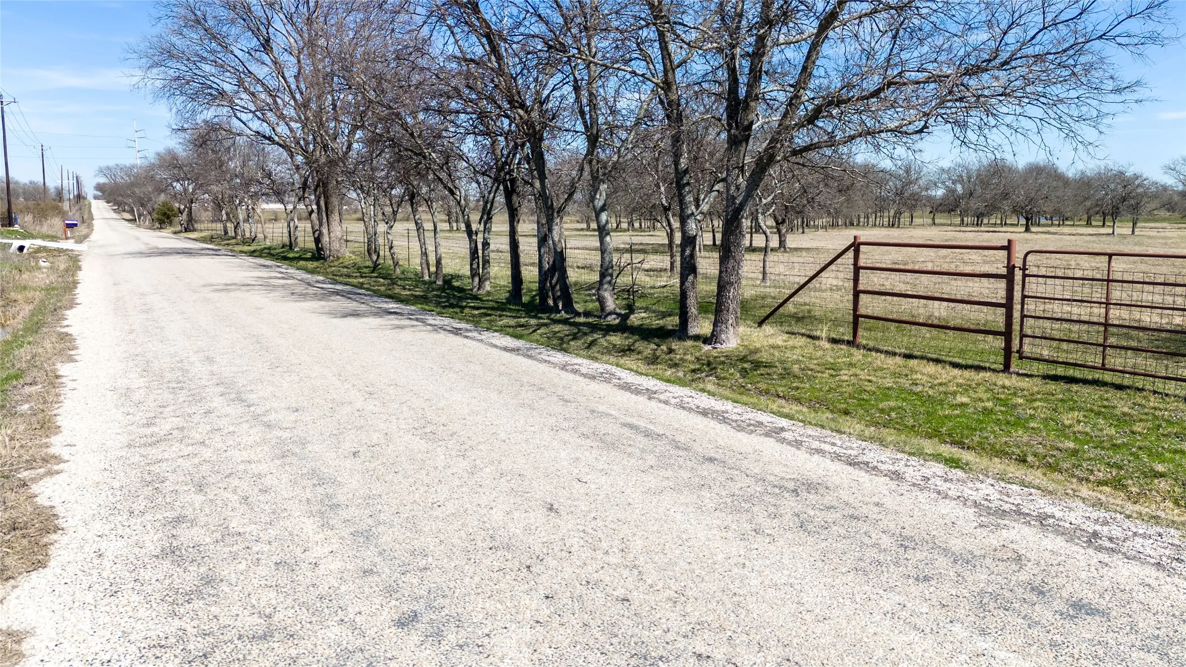 View of dirt / gravel road featuring a view of rural / pastoral area
