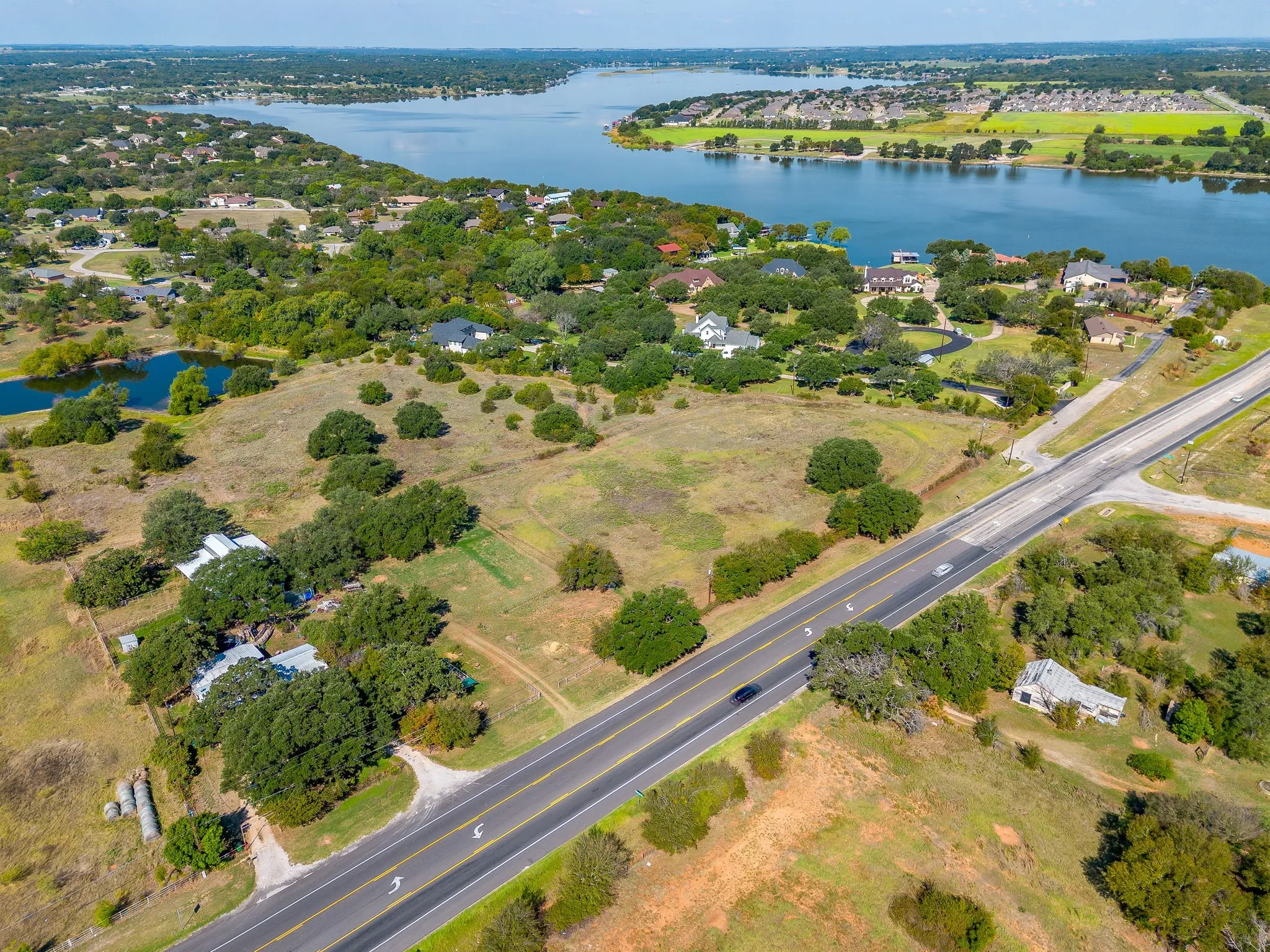 Aerial view of property and surrounding area with a nearby body of water