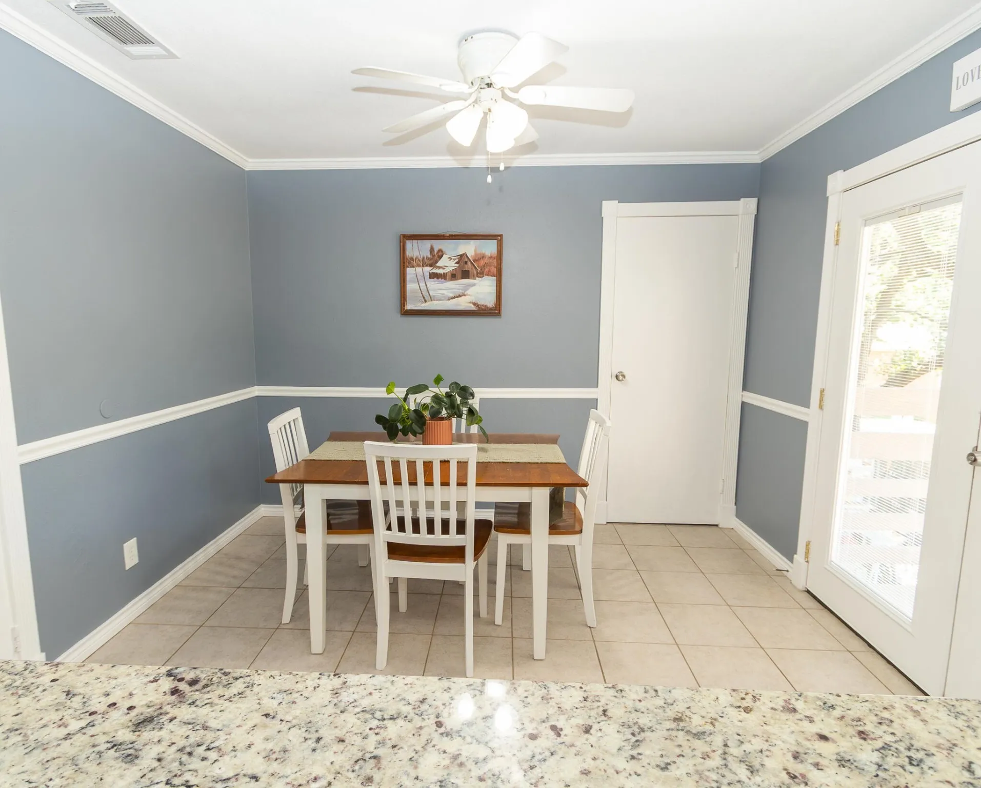 Dining room featuring light tile patterned floors, crown molding, and a ceiling fan