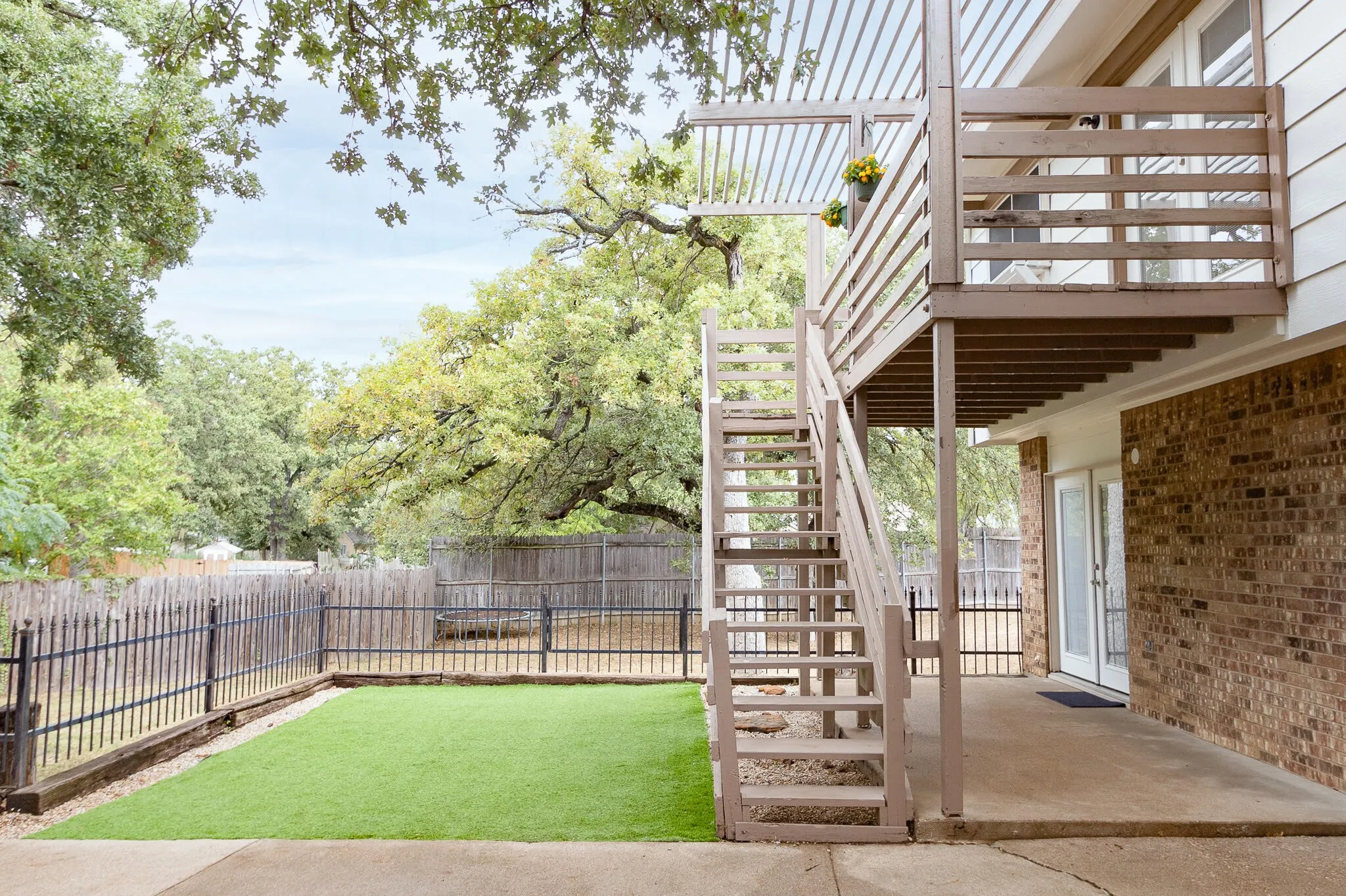 Fenced backyard featuring a patio area, stairway, and a wooden deck