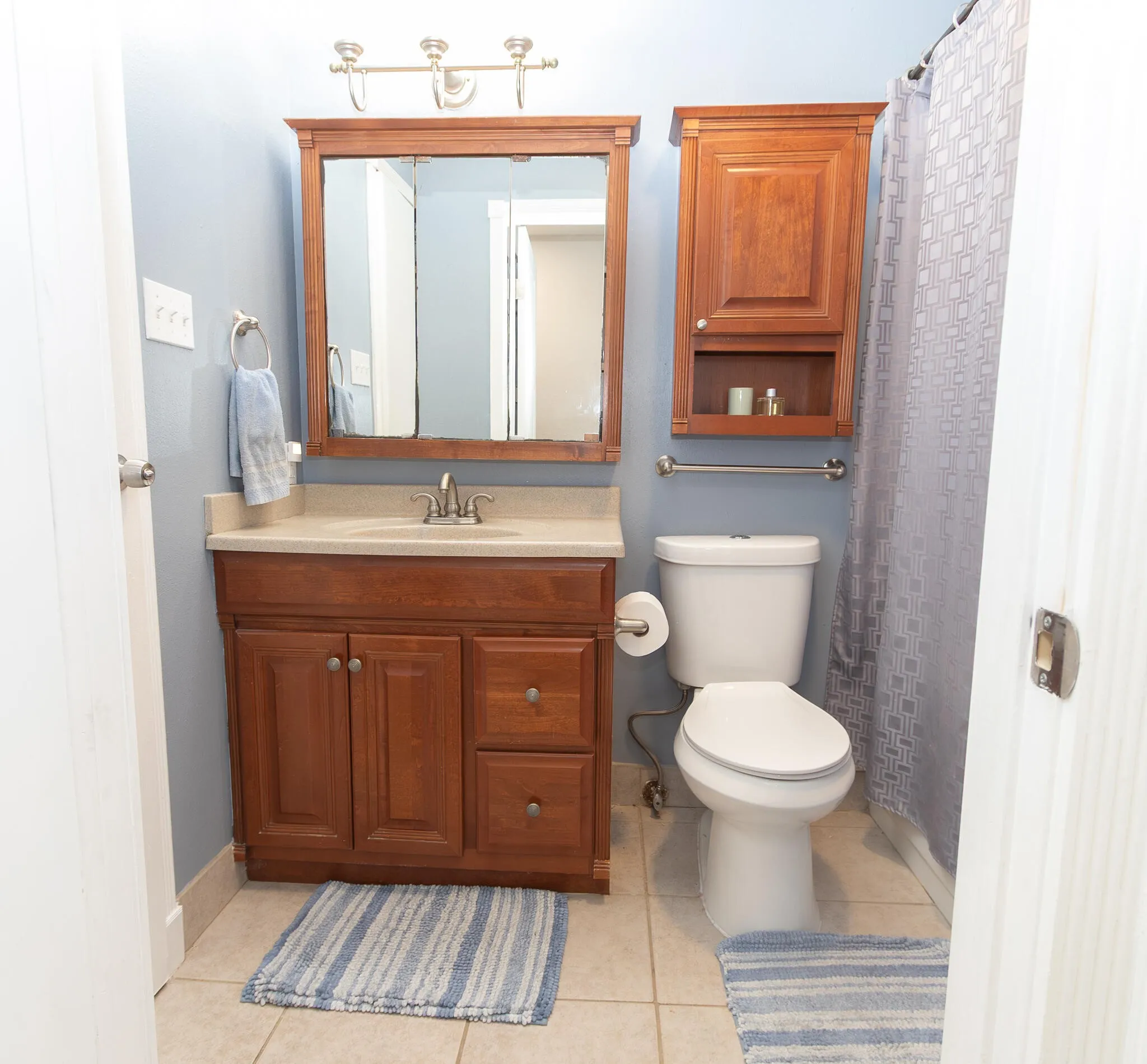 Bathroom with light tile patterned flooring, vanity, and a shower with curtain