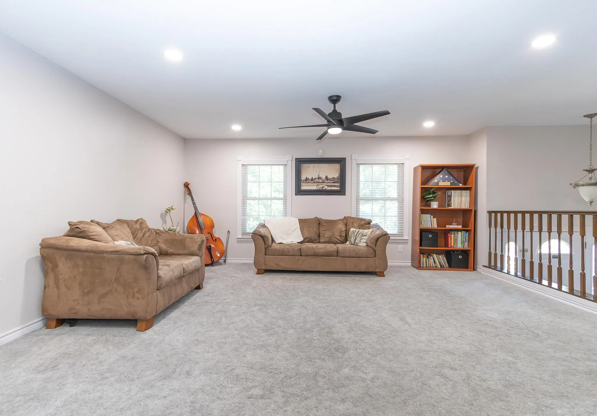 Living area featuring light carpet, ceiling fan, and recessed lighting