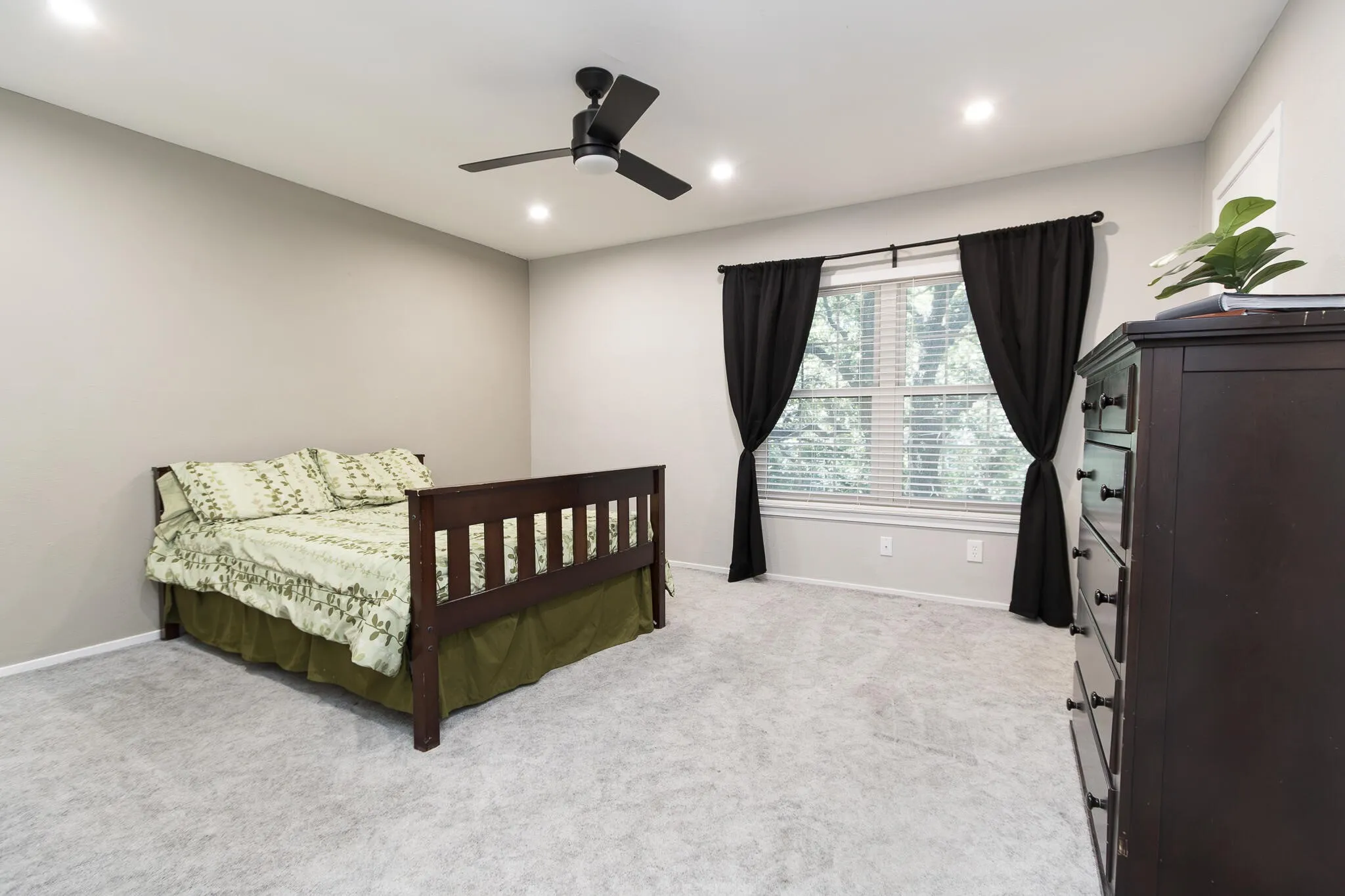 Bedroom with light carpet, recessed lighting, and a ceiling fan