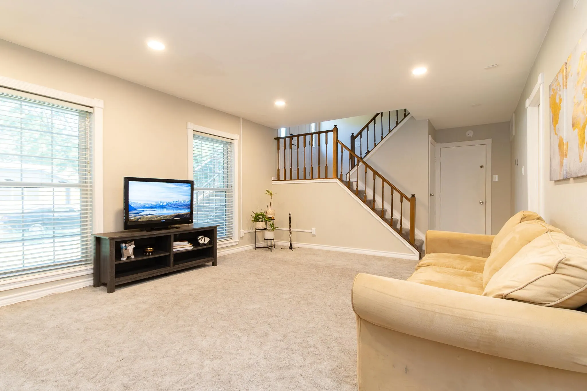 Living room with recessed lighting, carpet floors, and stairway