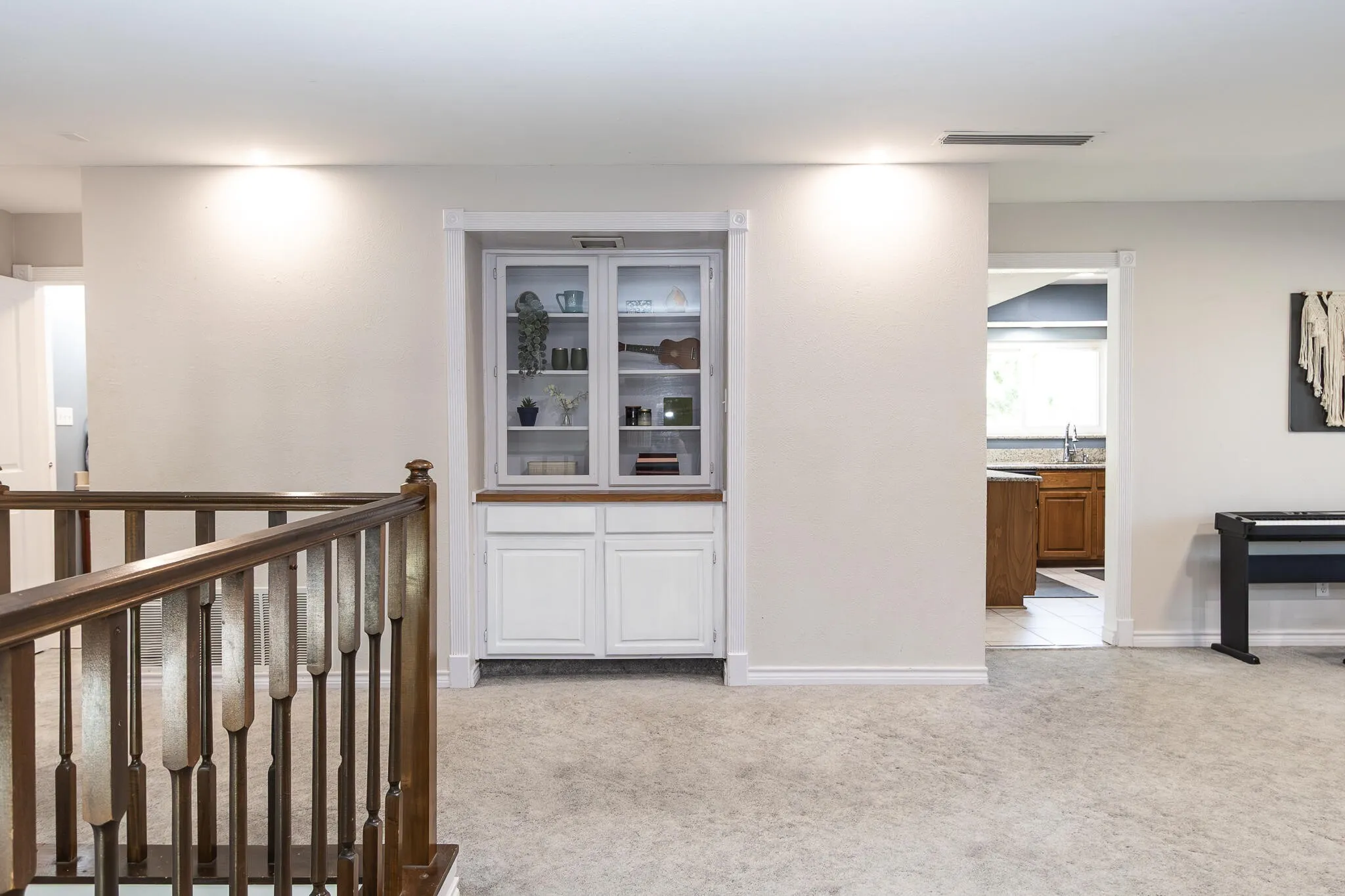 Hall featuring light colored carpet and an upstairs landing