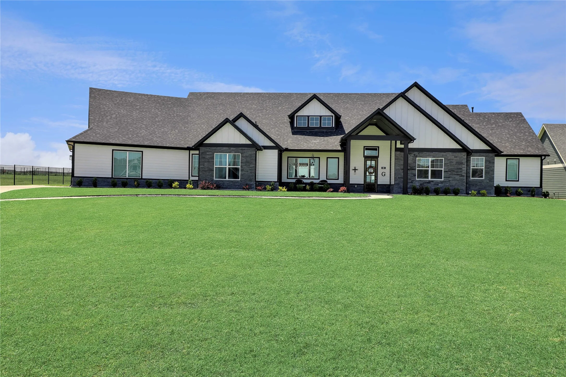 View of front of property with stone siding and roof with shingles