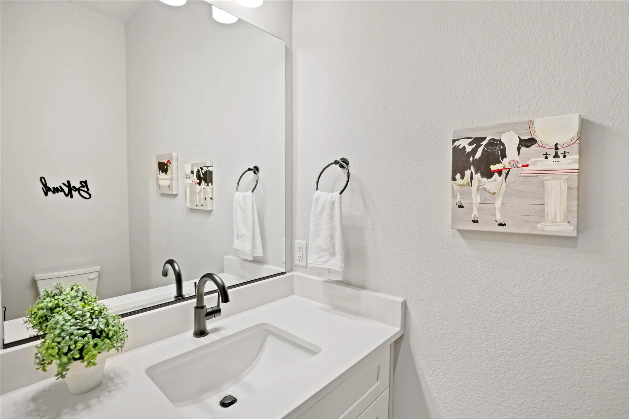 Half bath with vanity and a textured wall