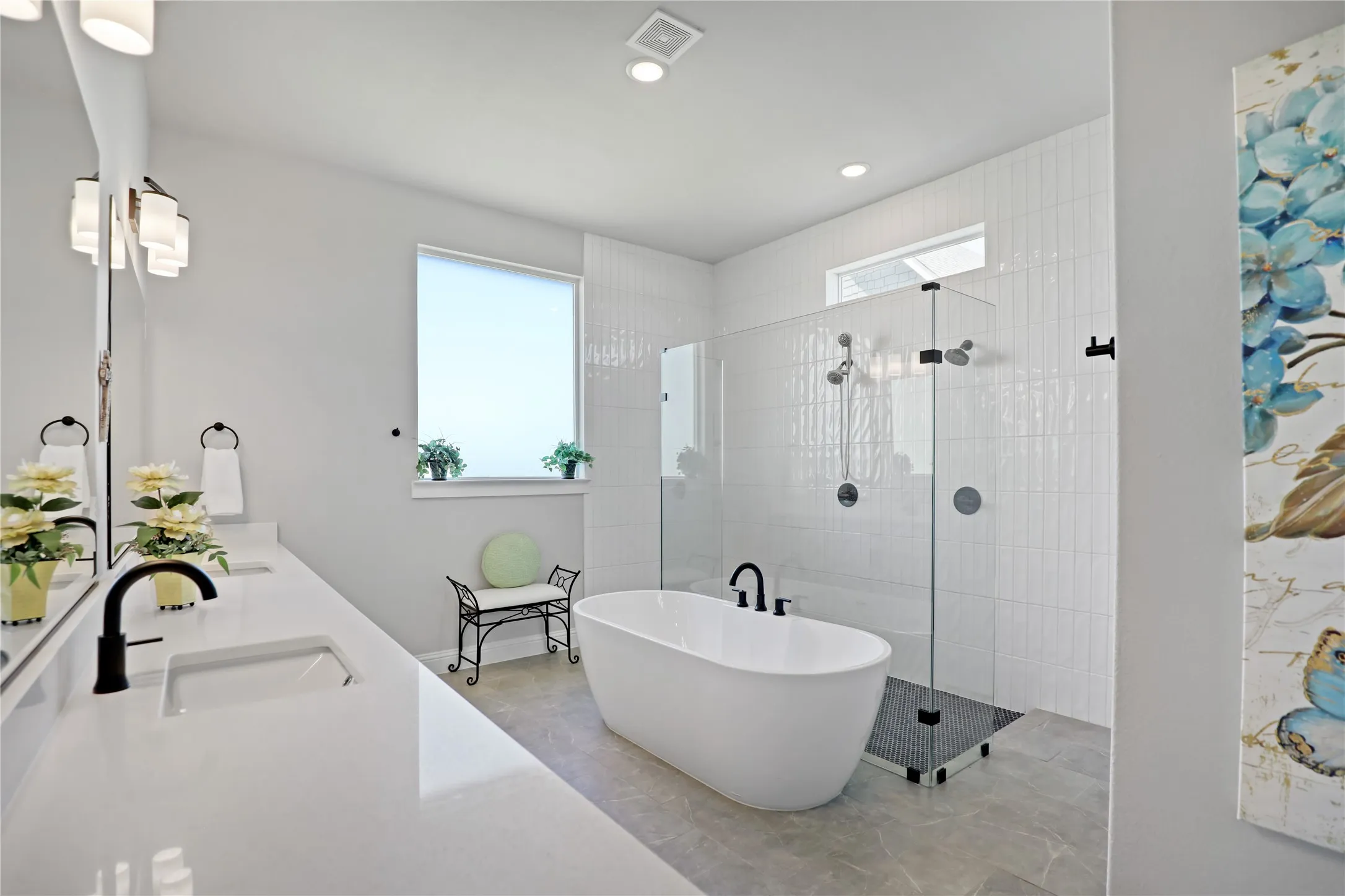 Bathroom featuring healthy amount of natural light, a freestanding tub, double vanity, walk in shower, and recessed lighting