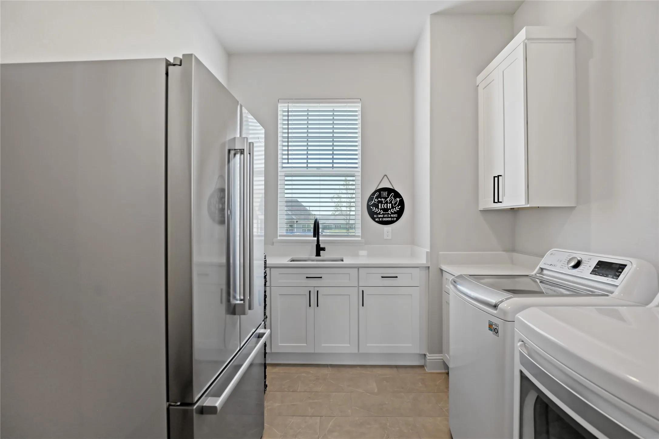 Laundry room with light tile patterned flooring and washing machine and dryer
