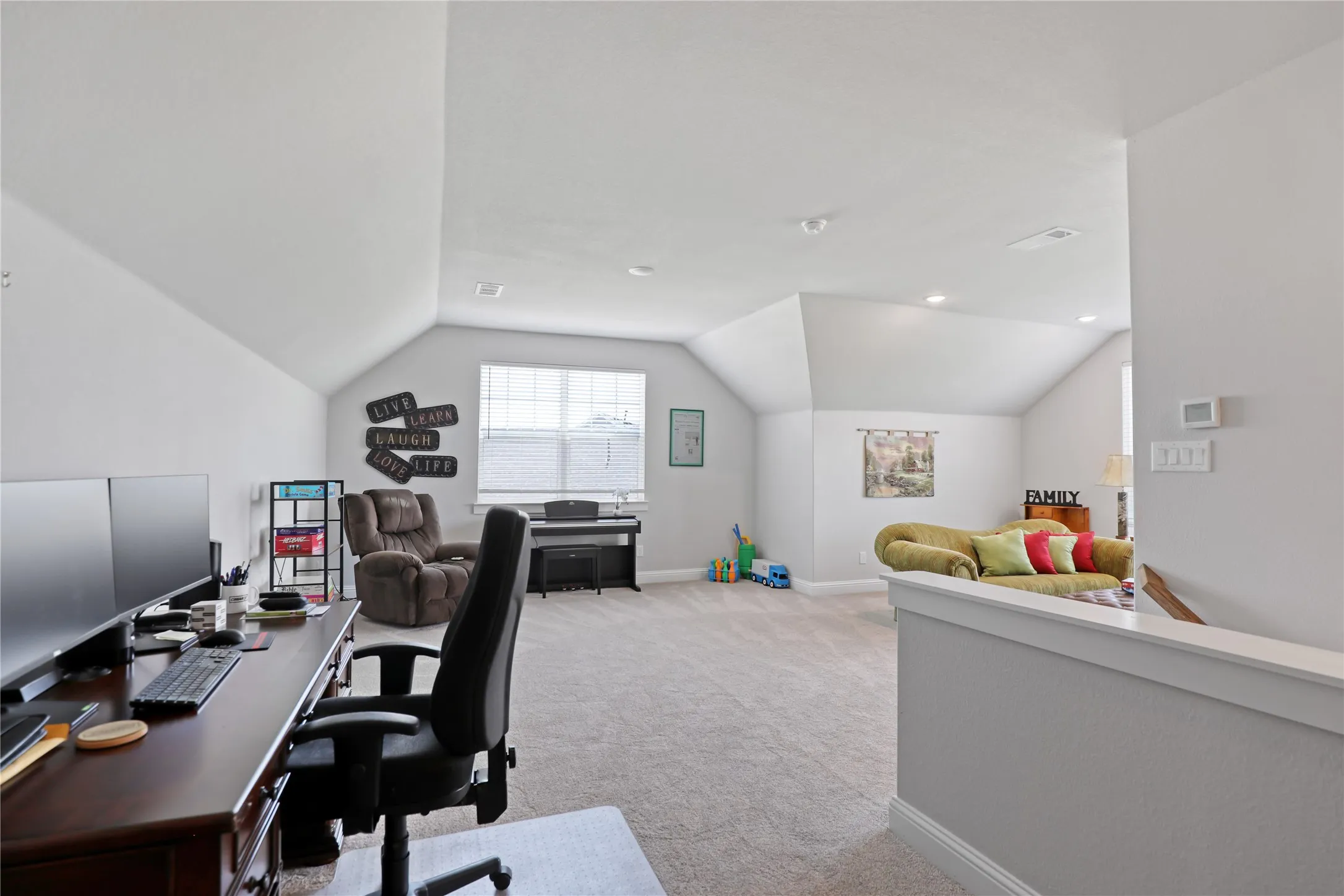 Office area with light colored carpet, vaulted ceiling, and recessed lighting