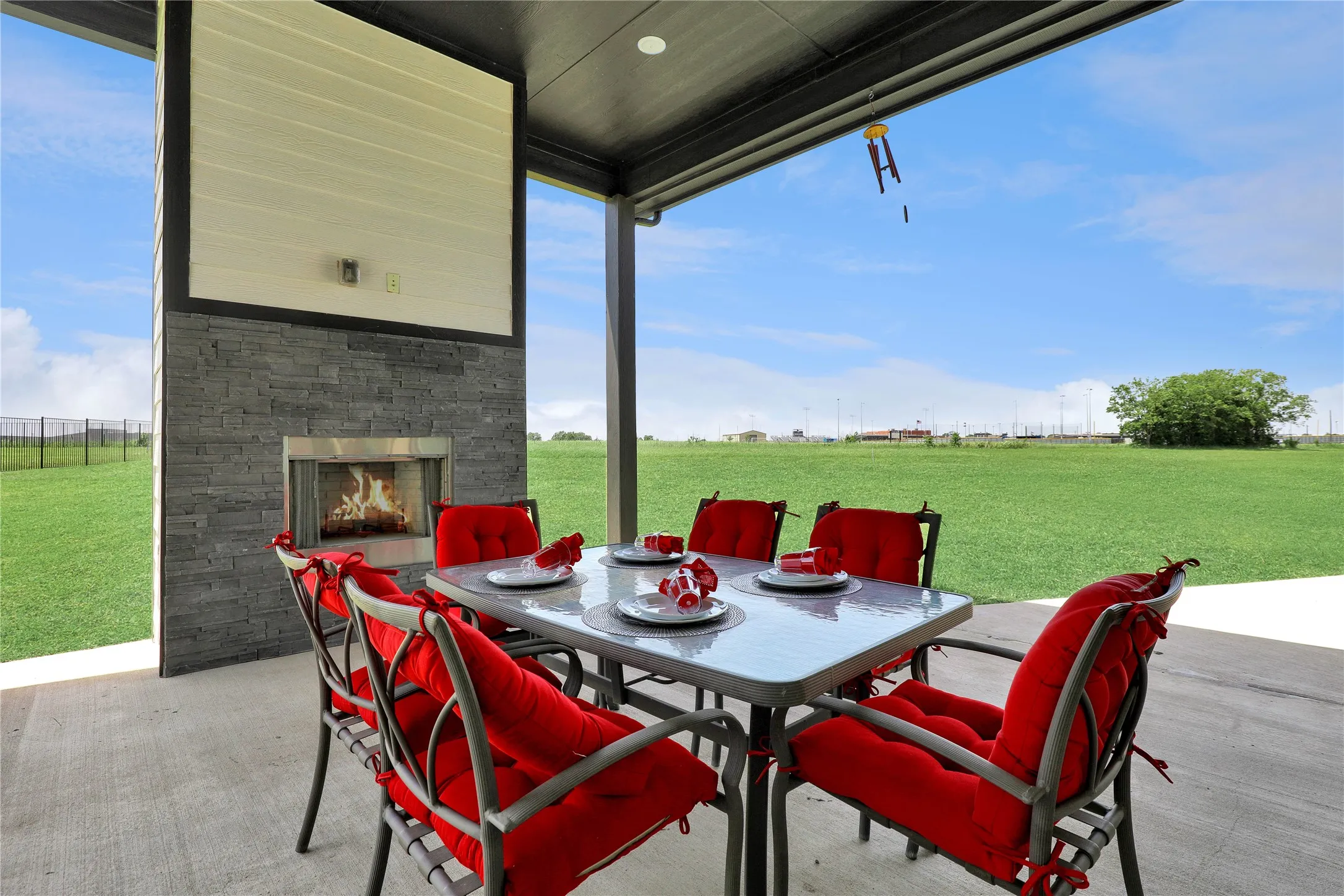 View of patio featuring an outdoor stone fireplace and outdoor dining area