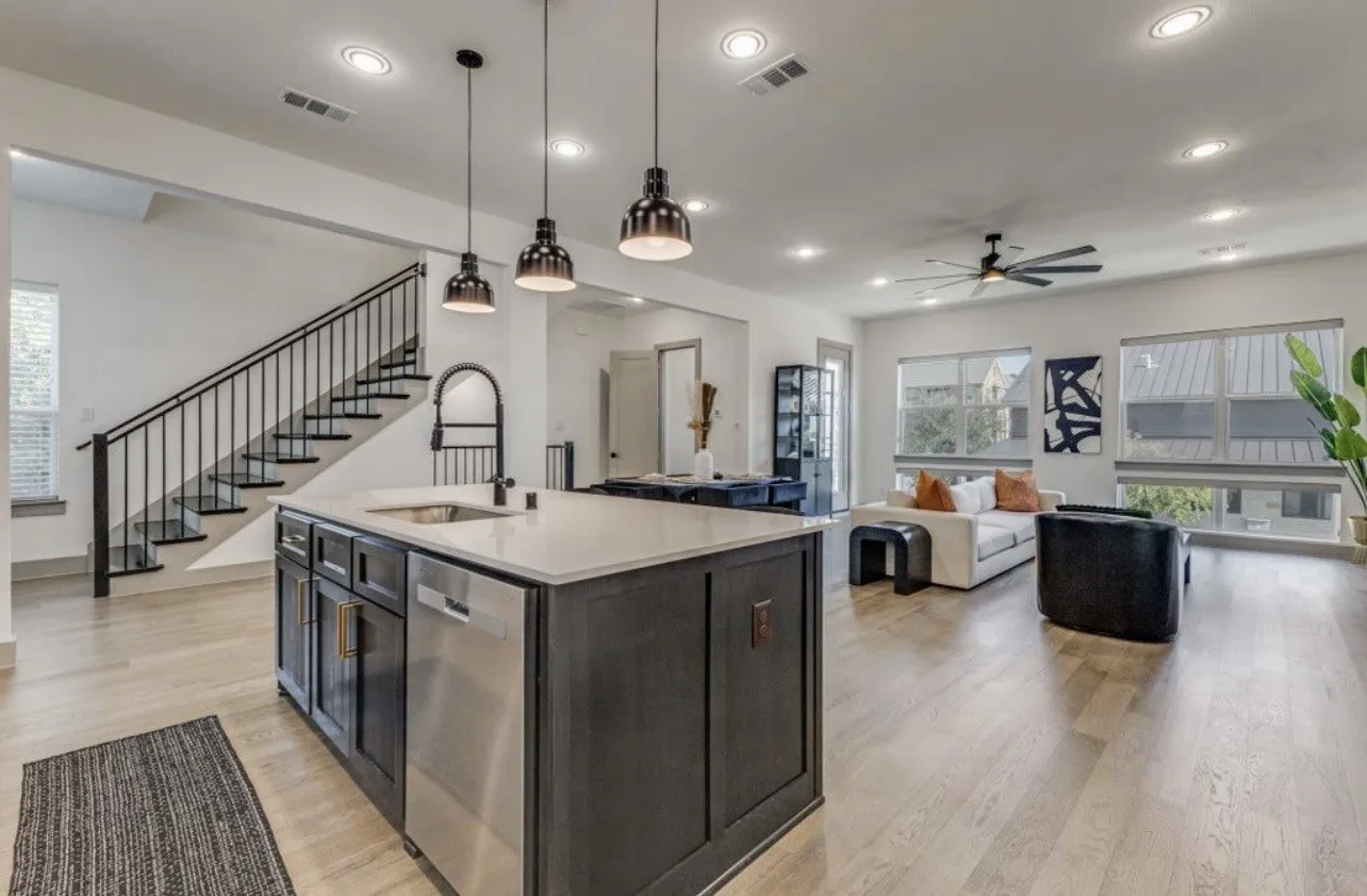 Kitchen featuring large, open island, pendant lighting, stainless appliances, light wood-type flooring, and an open floor plan
