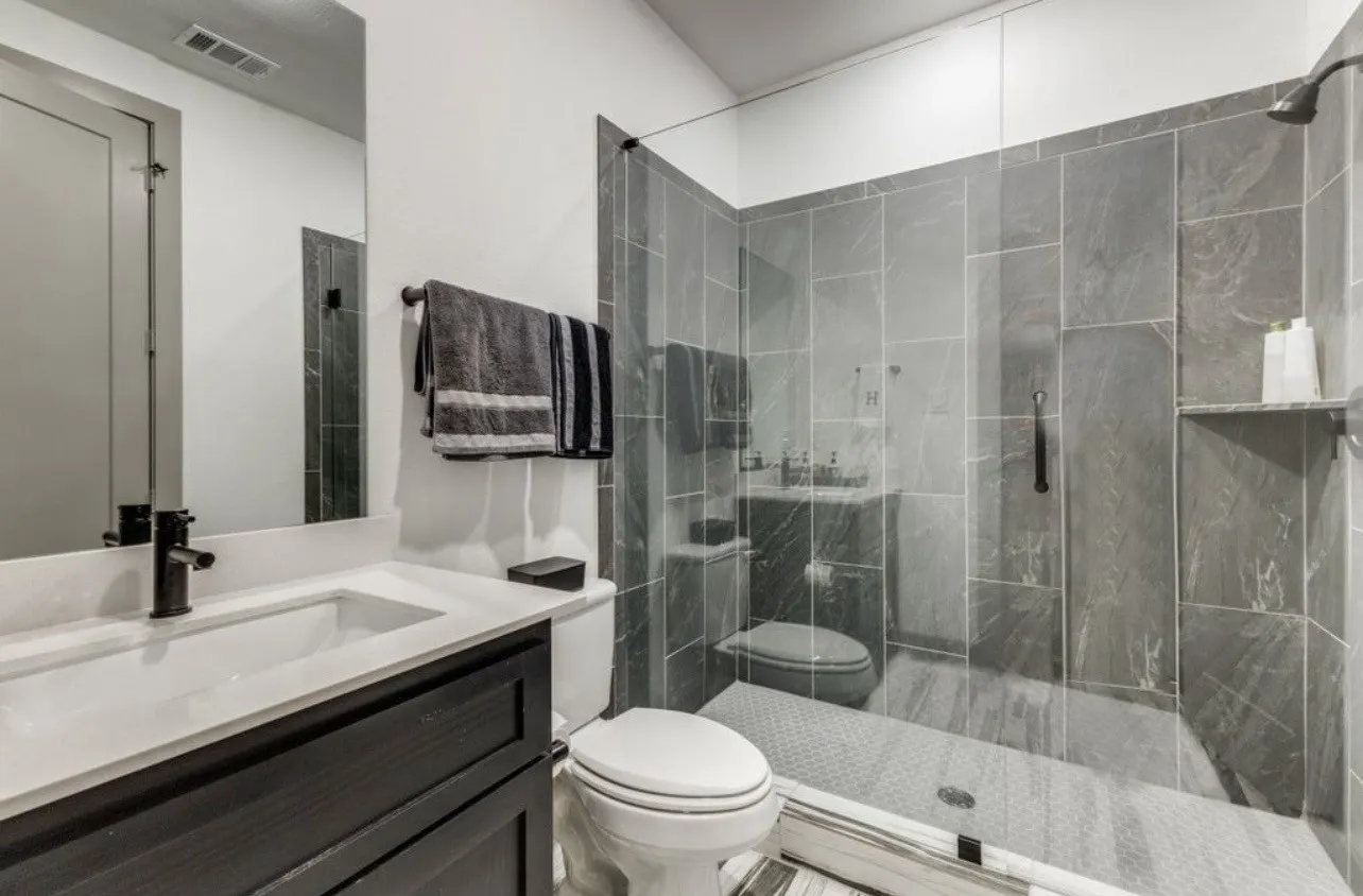 Full bath with a marble finish shower and vanity