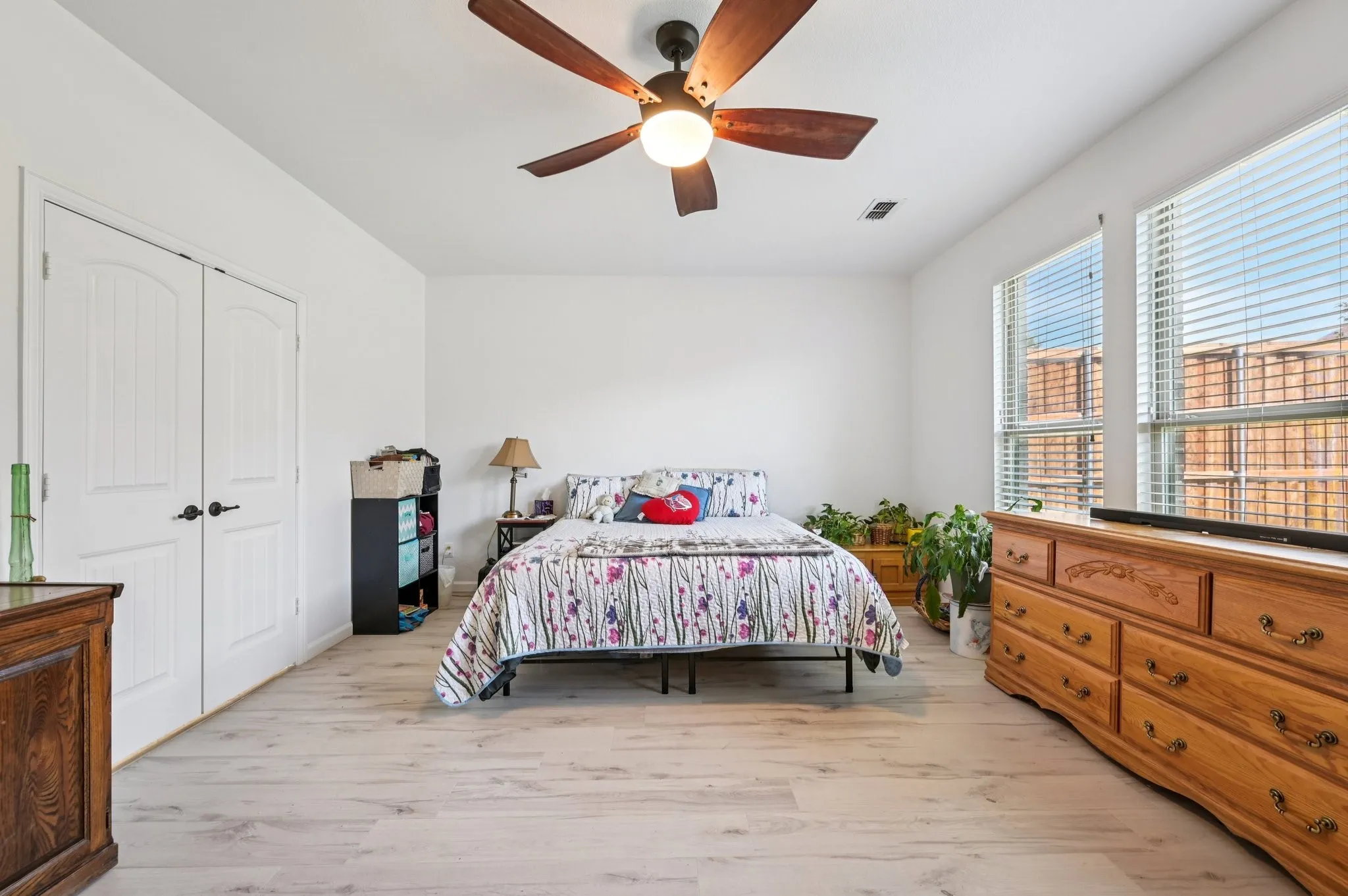 Bedroom featuring light wood finished floors, ceiling fan, and a closet