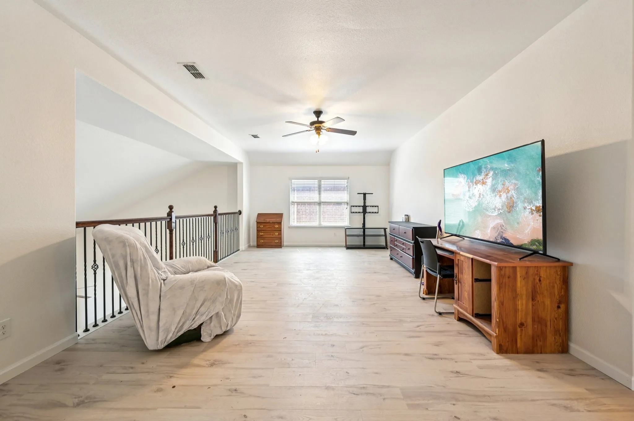 Sitting room with light wood-type flooring and ceiling fan