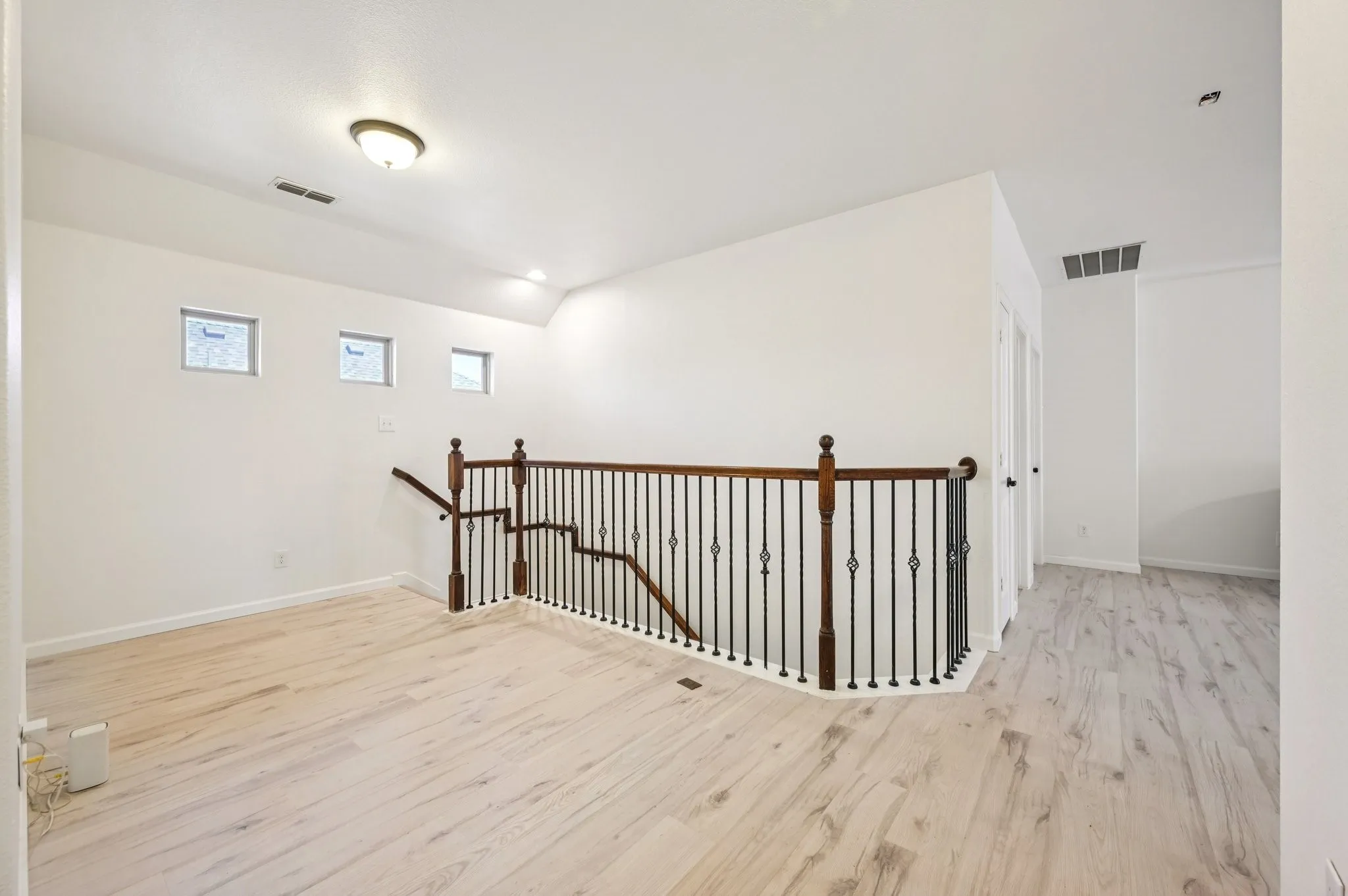 Corridor featuring an upstairs landing and light wood-style floors