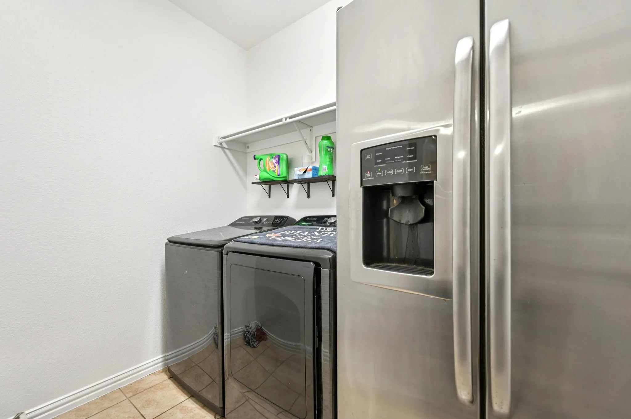 Washroom featuring light tile patterned floors and washing machine and dryer