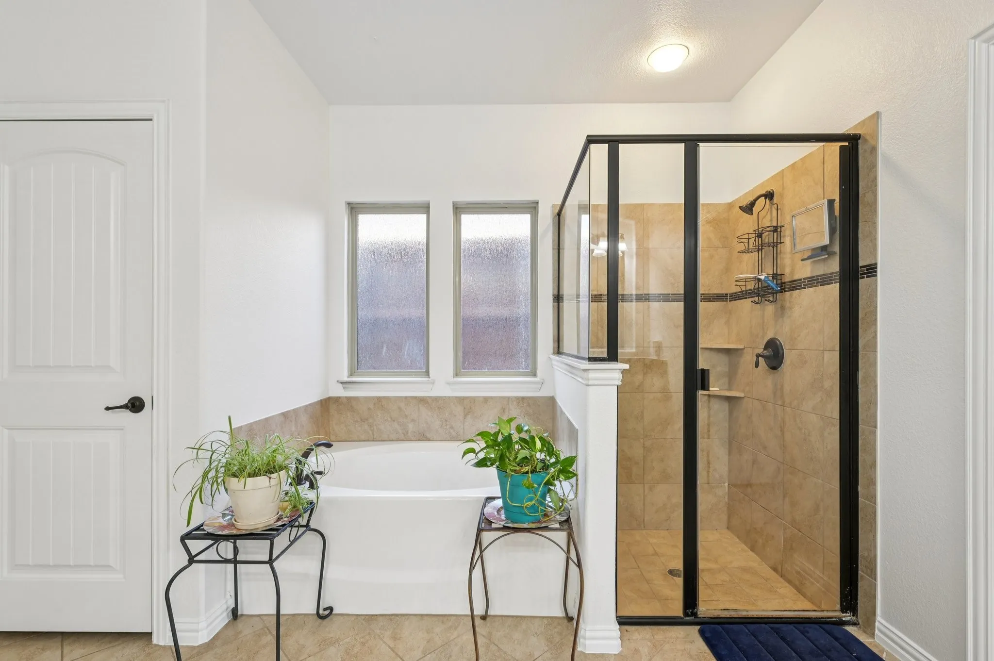 Full bathroom with a stall shower, a garden tub, and tile patterned flooring