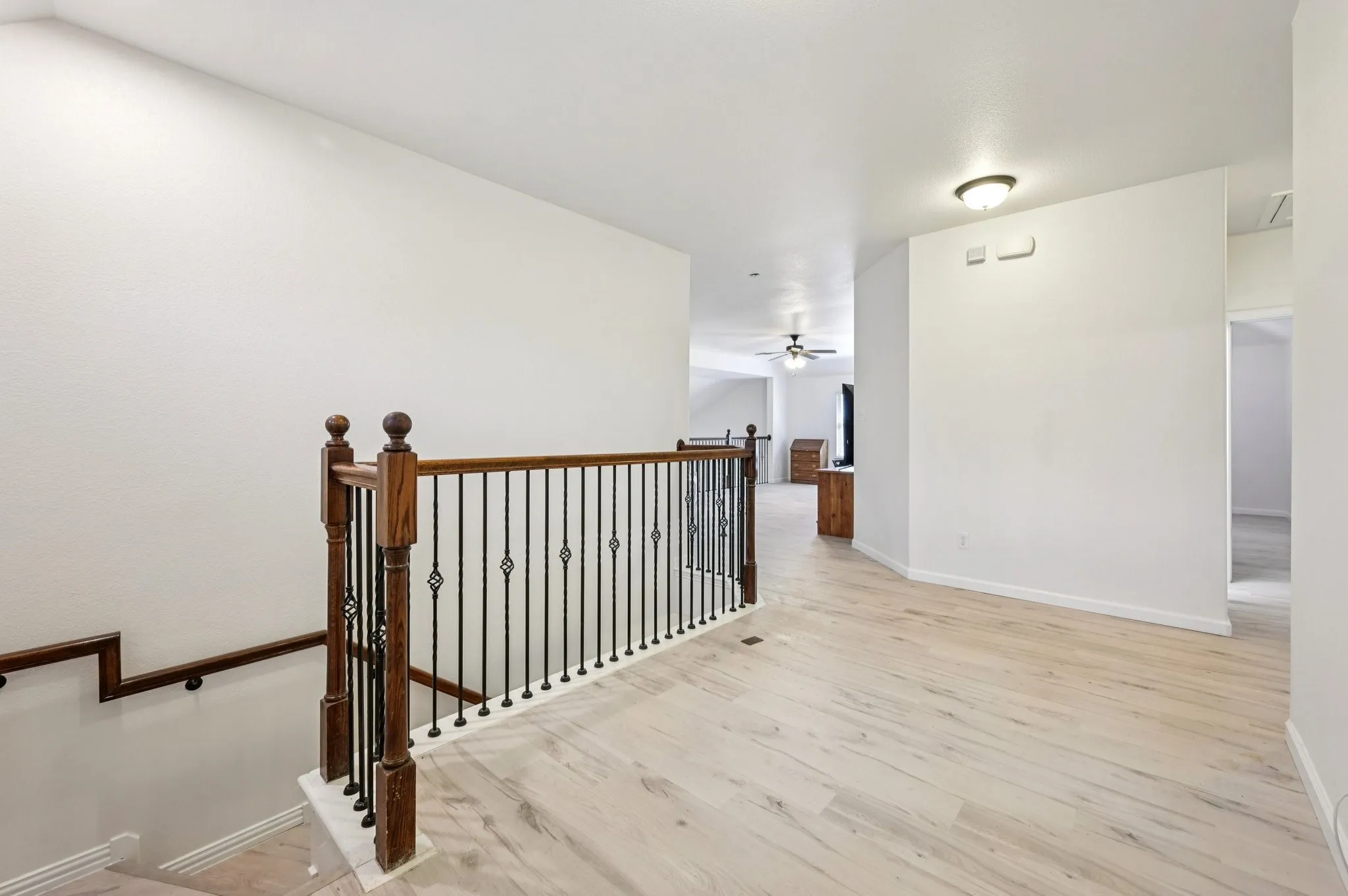 Hall featuring light wood finished floors and an upstairs landing