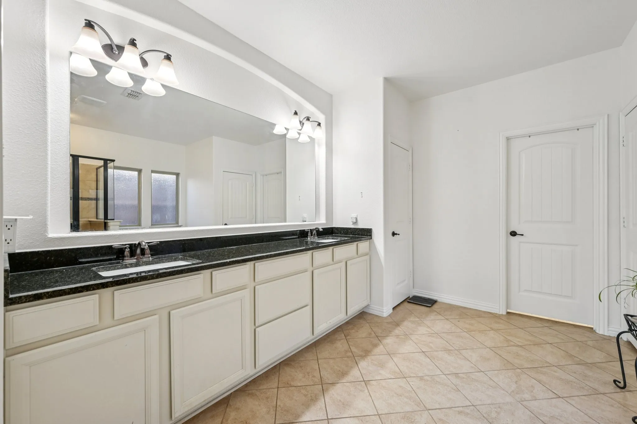 Full bath featuring double vanity and light tile patterned flooring