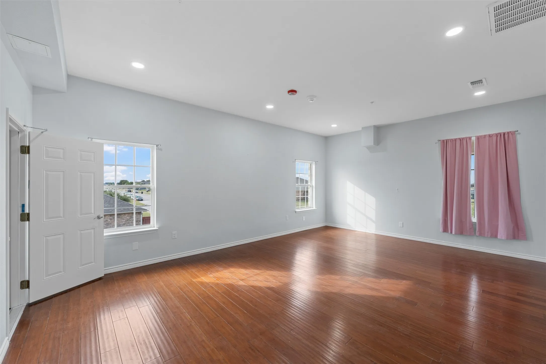 Empty room featuring dark wood finished floors and recessed lighting