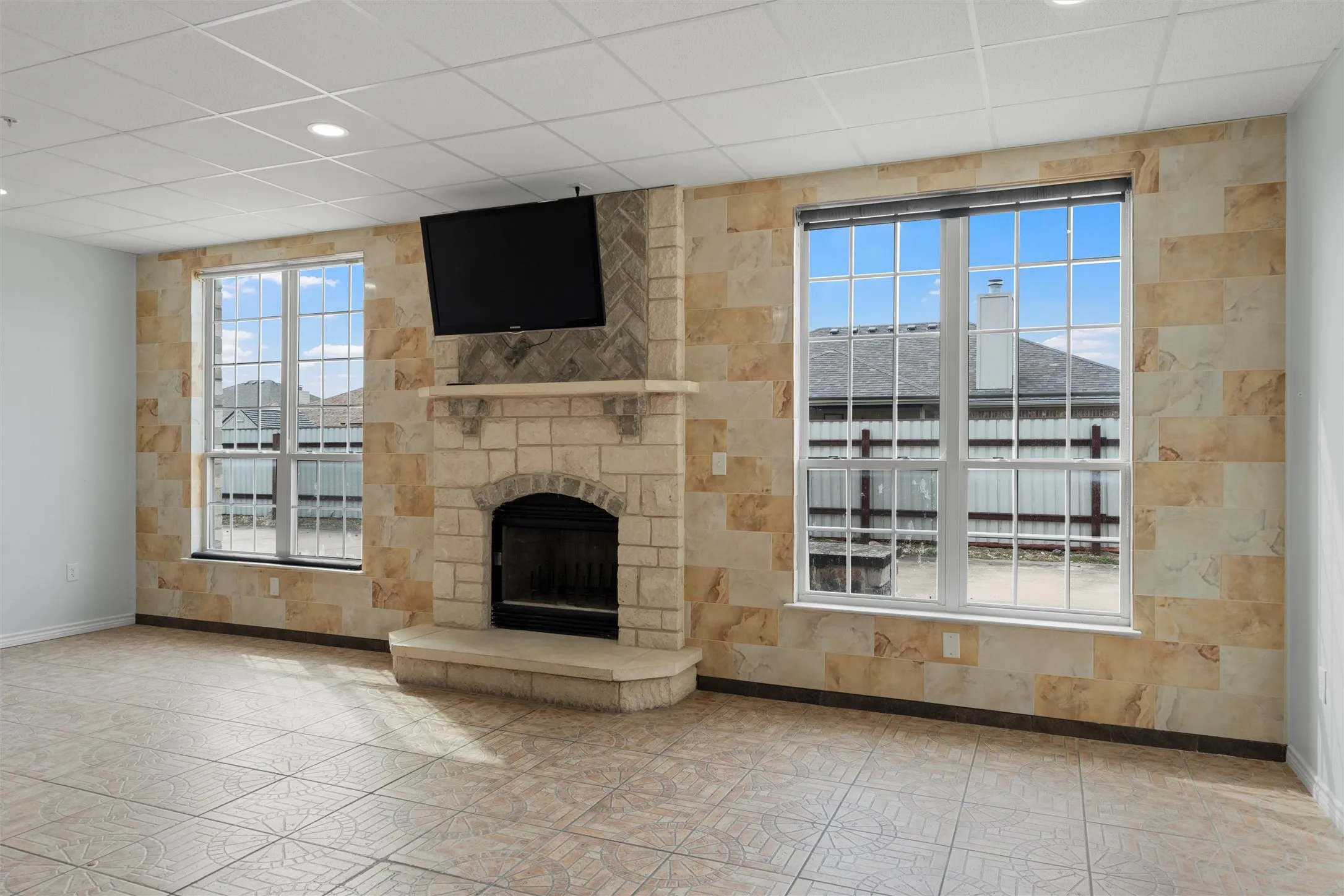 Unfurnished living room with a fireplace and a drop ceiling