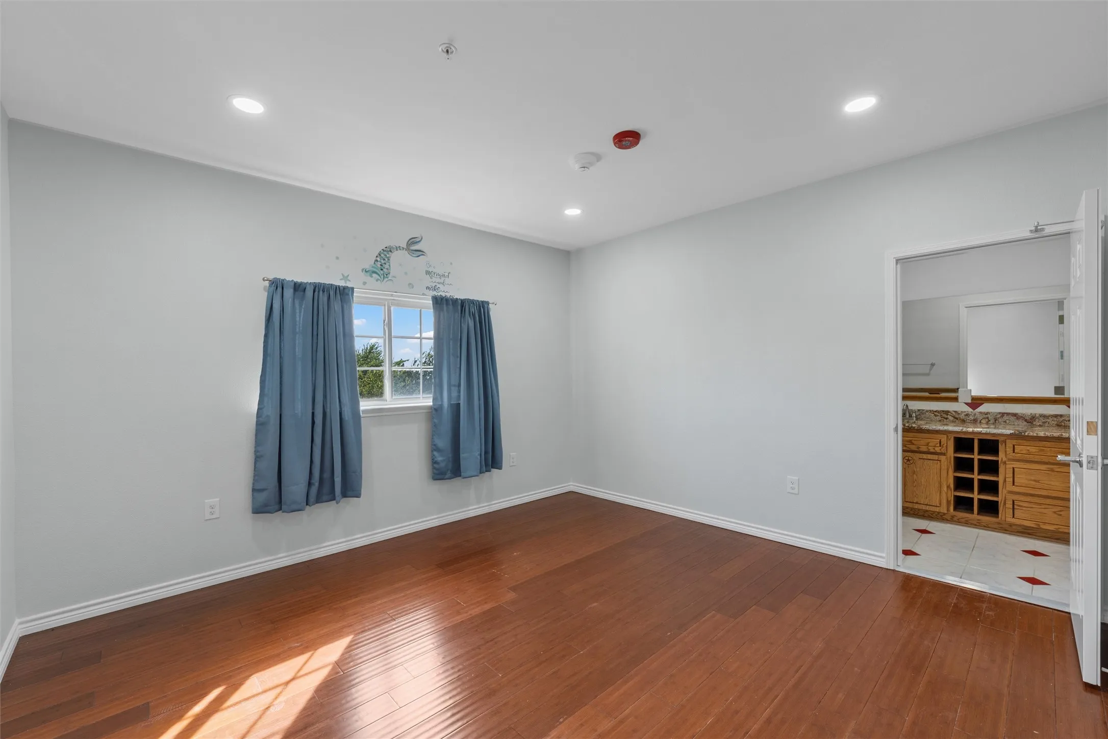 Empty room featuring dark wood finished floors and recessed lighting