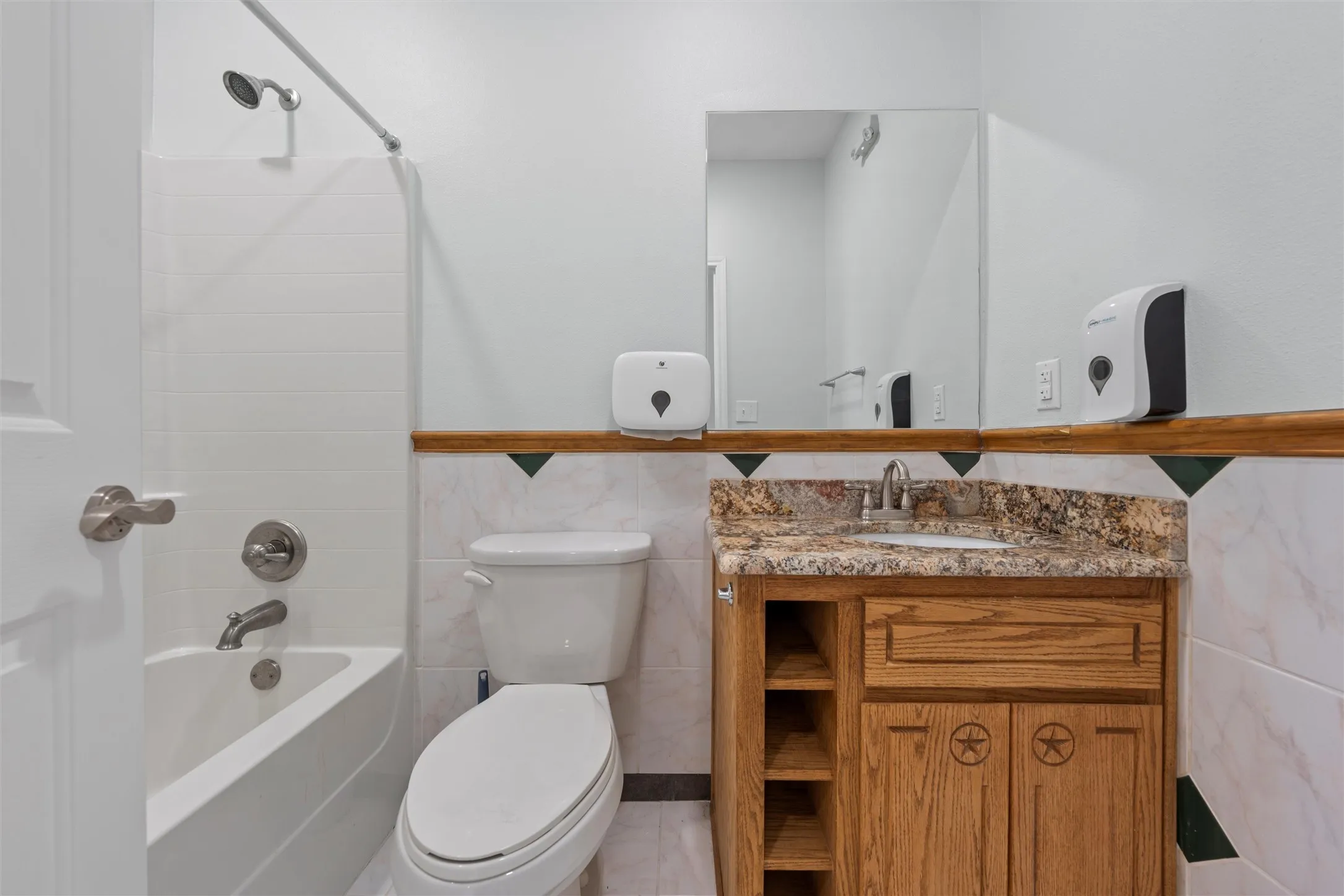 Bathroom featuring tile walls, shower / washtub combination, and vanity