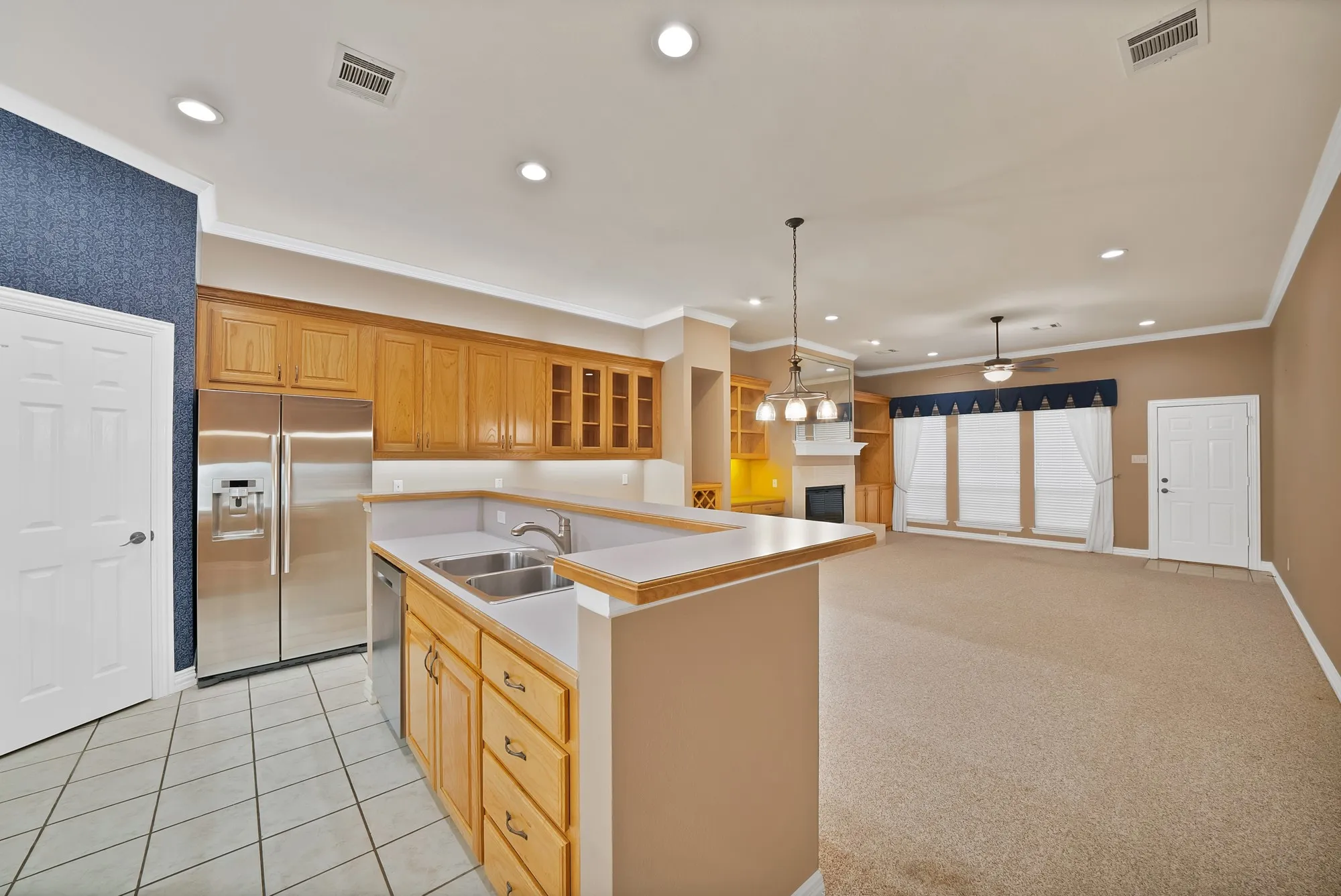 Kitchen featuring appliances with stainless steel finishes, a ceiling fan, recessed lighting, pendant lighting, and light countertops