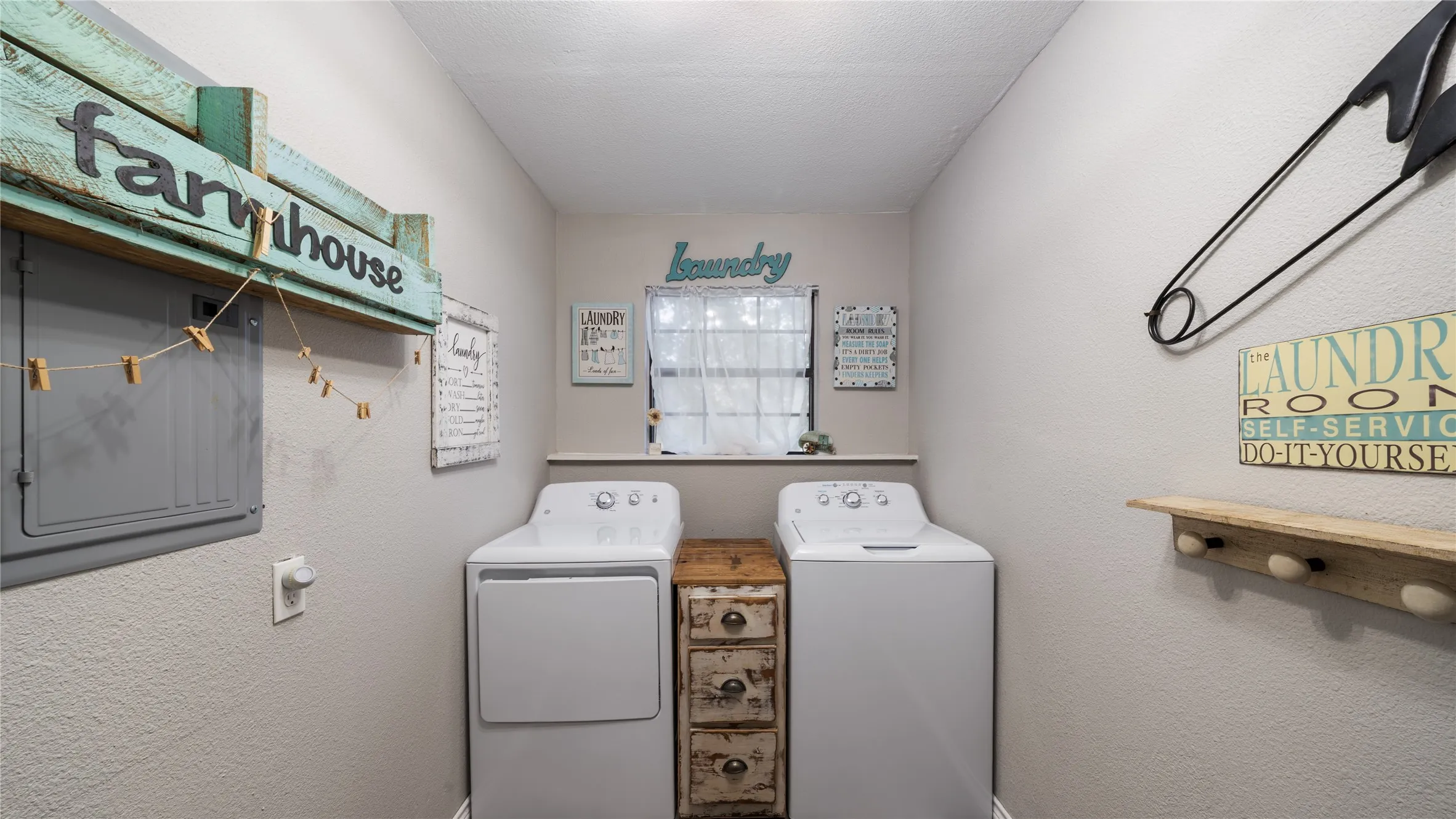 Laundry room with a textured wall, washer and clothes dryer, and a textured ceiling