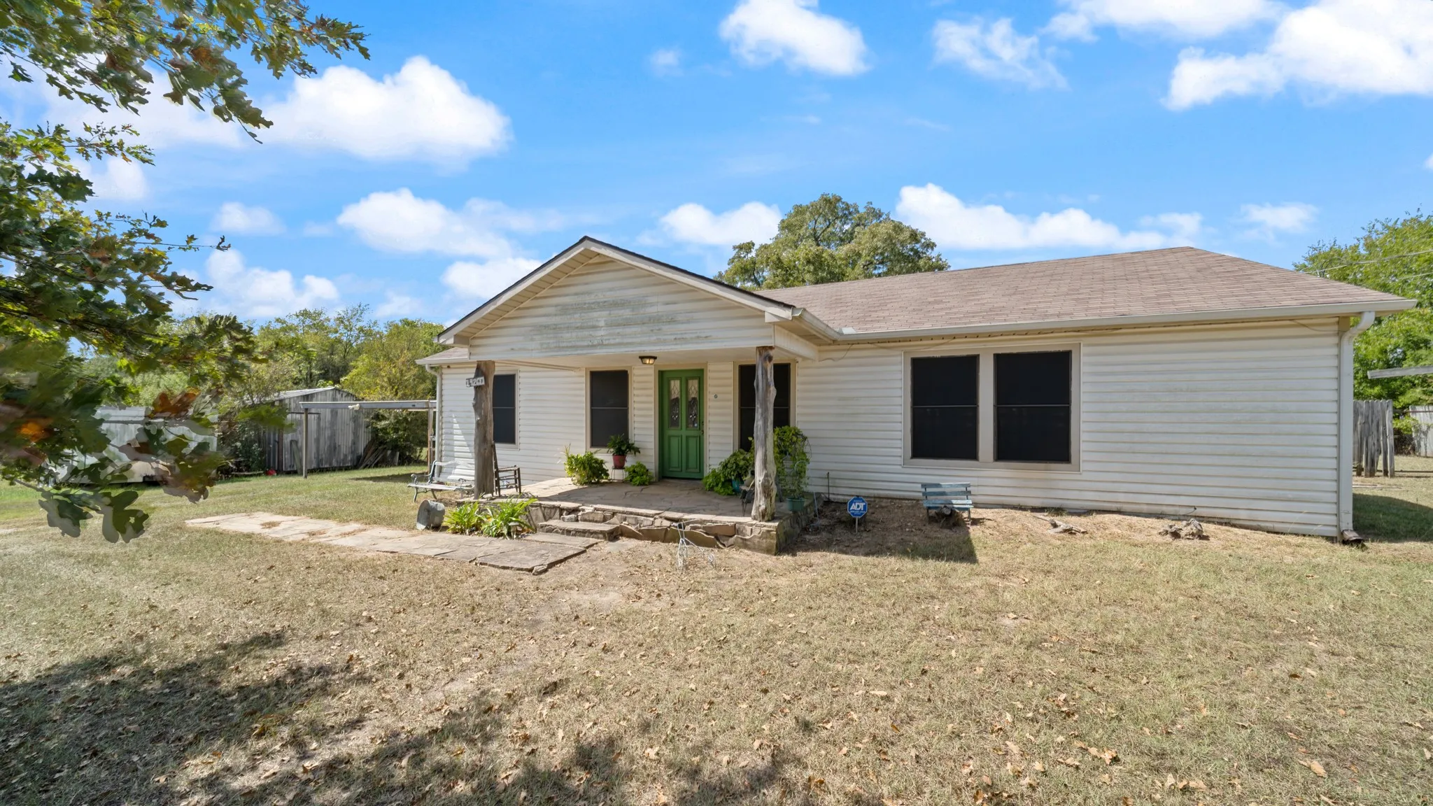 Ranch-style home featuring a porch and roof with shingles