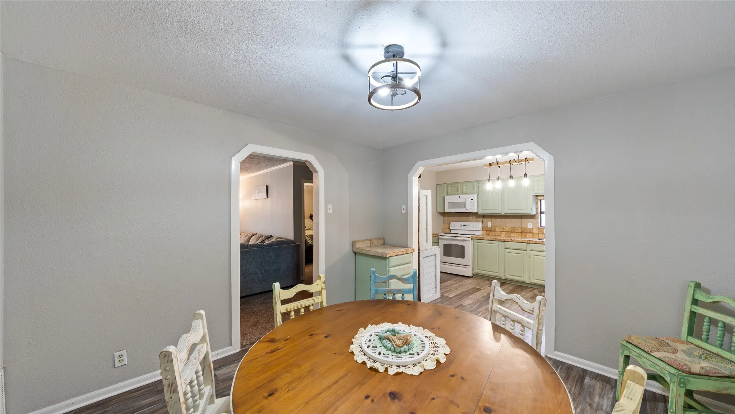 Dining room featuring arched walkways and light wood-type flooring