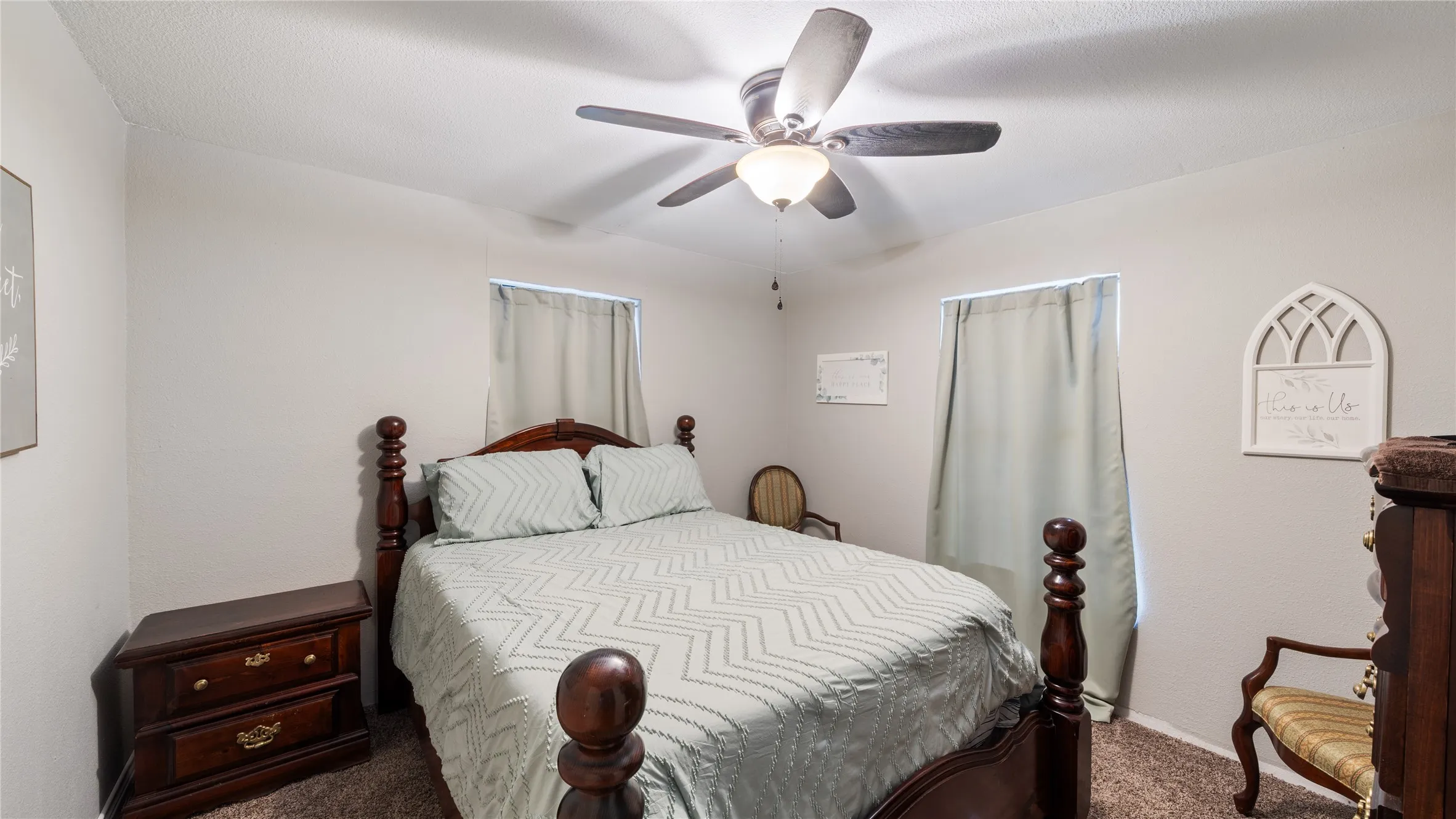 Carpeted bedroom with a ceiling fan and baseboards