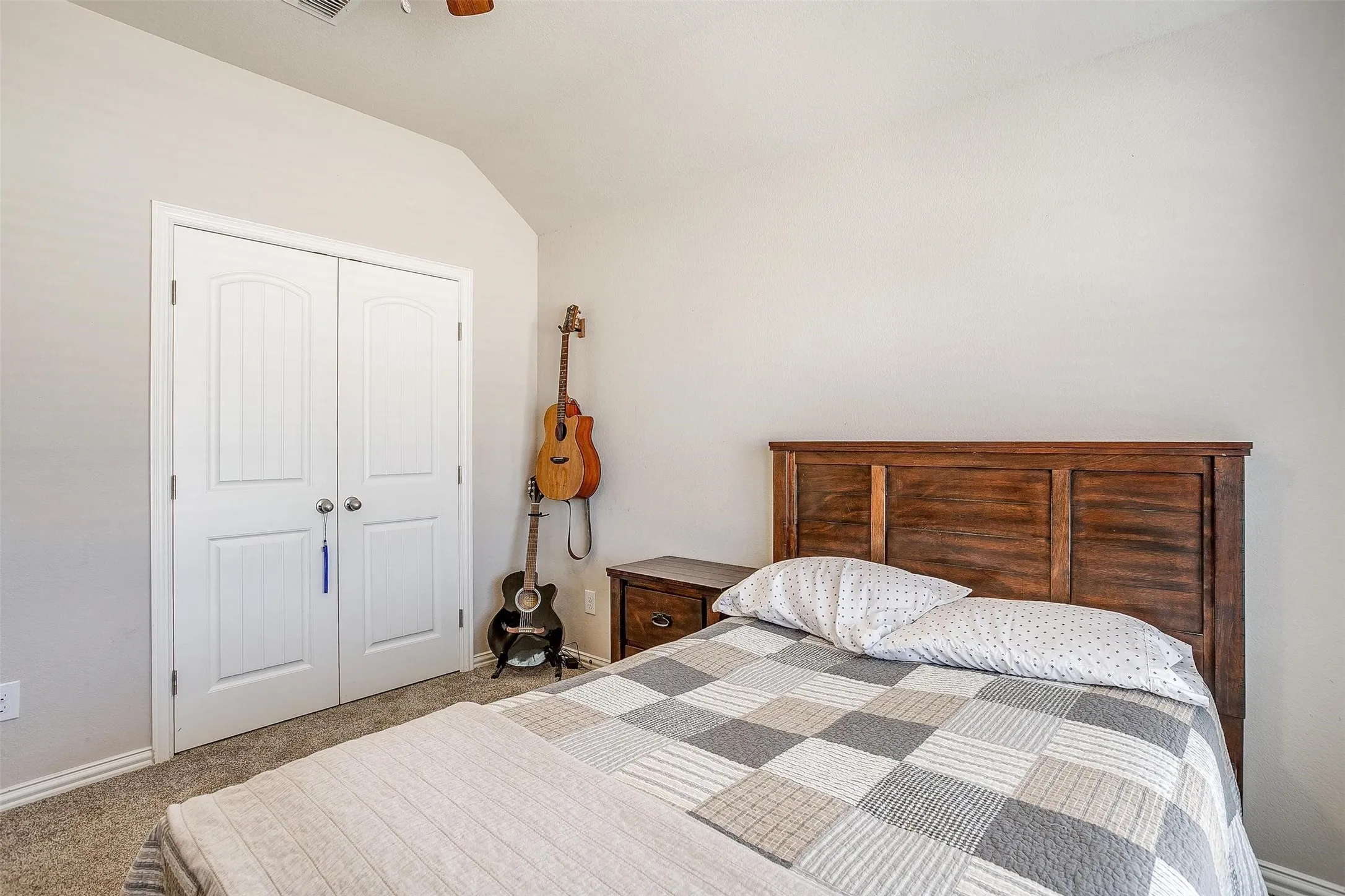 Bedroom featuring carpet flooring, a closet, vaulted ceiling, and a ceiling fan