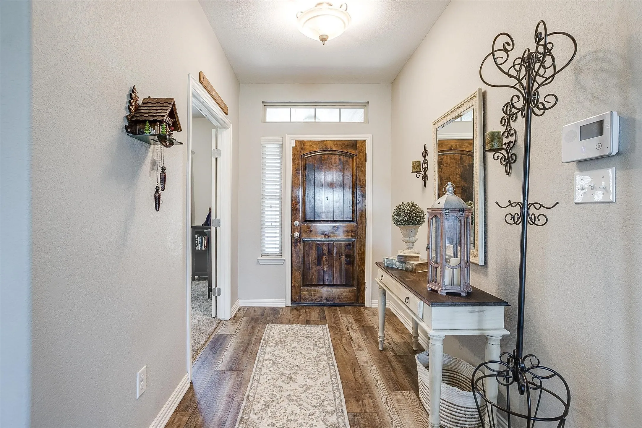 Foyer entrance featuring dark wood-style flooring and a textured wall