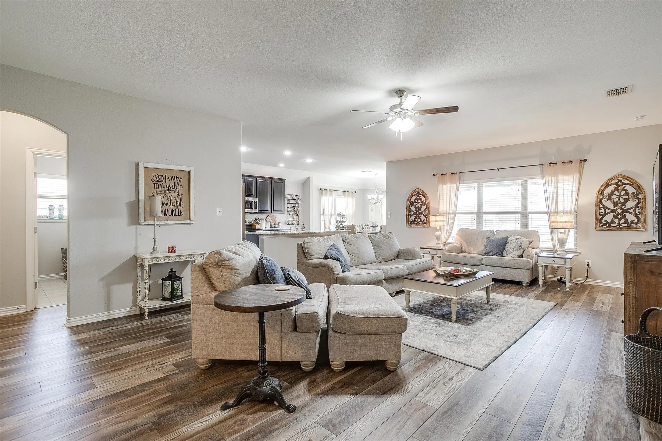 Living room with arched walkways, wood-type flooring, and ceiling​​‌​​​​‌​​‌‌​‌‌​​​‌‌​‌​‌​‌​​​‌​​ fan