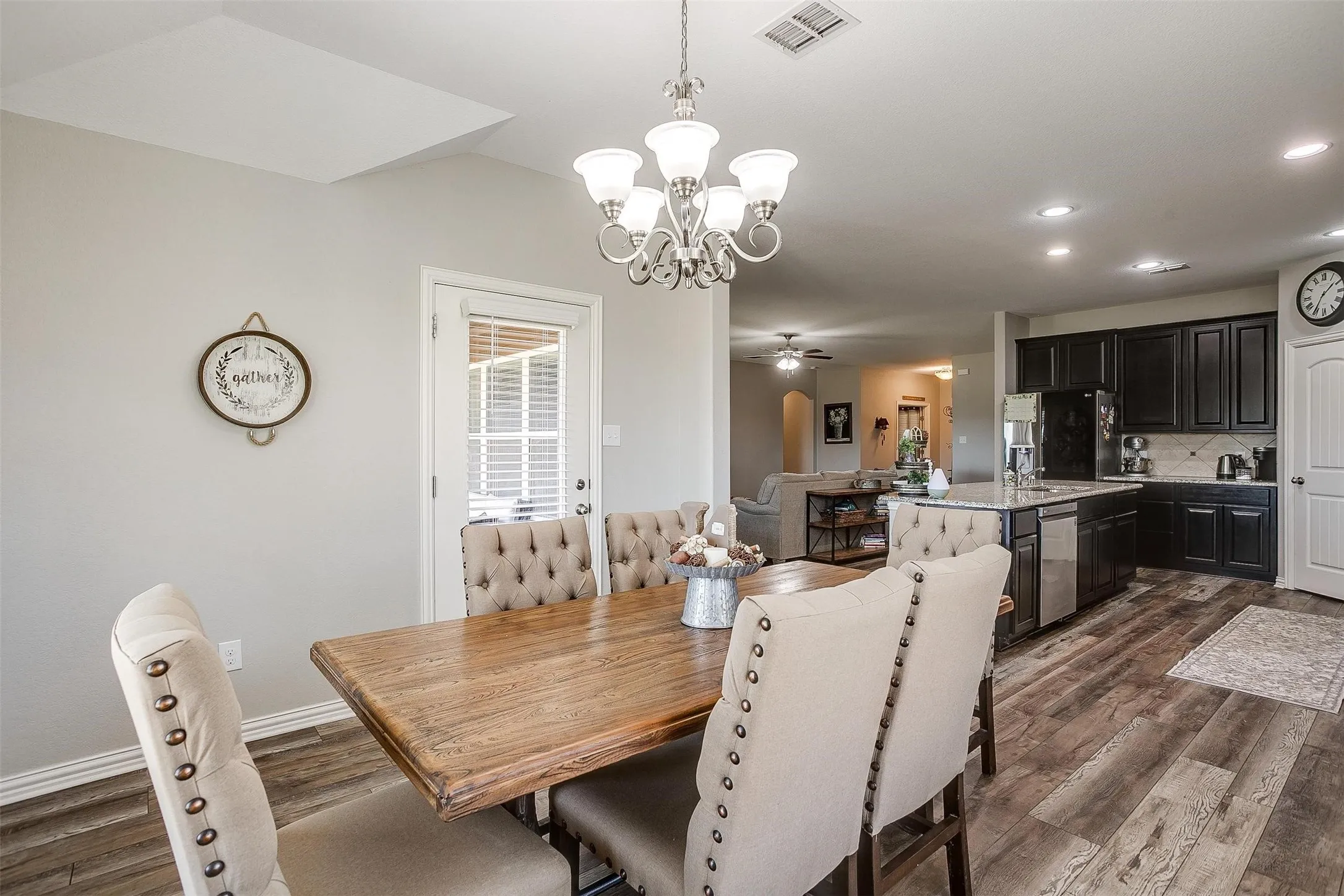 Dining space with dark wood-type flooring, ceiling fan, a chandelier, and recessed lighting
