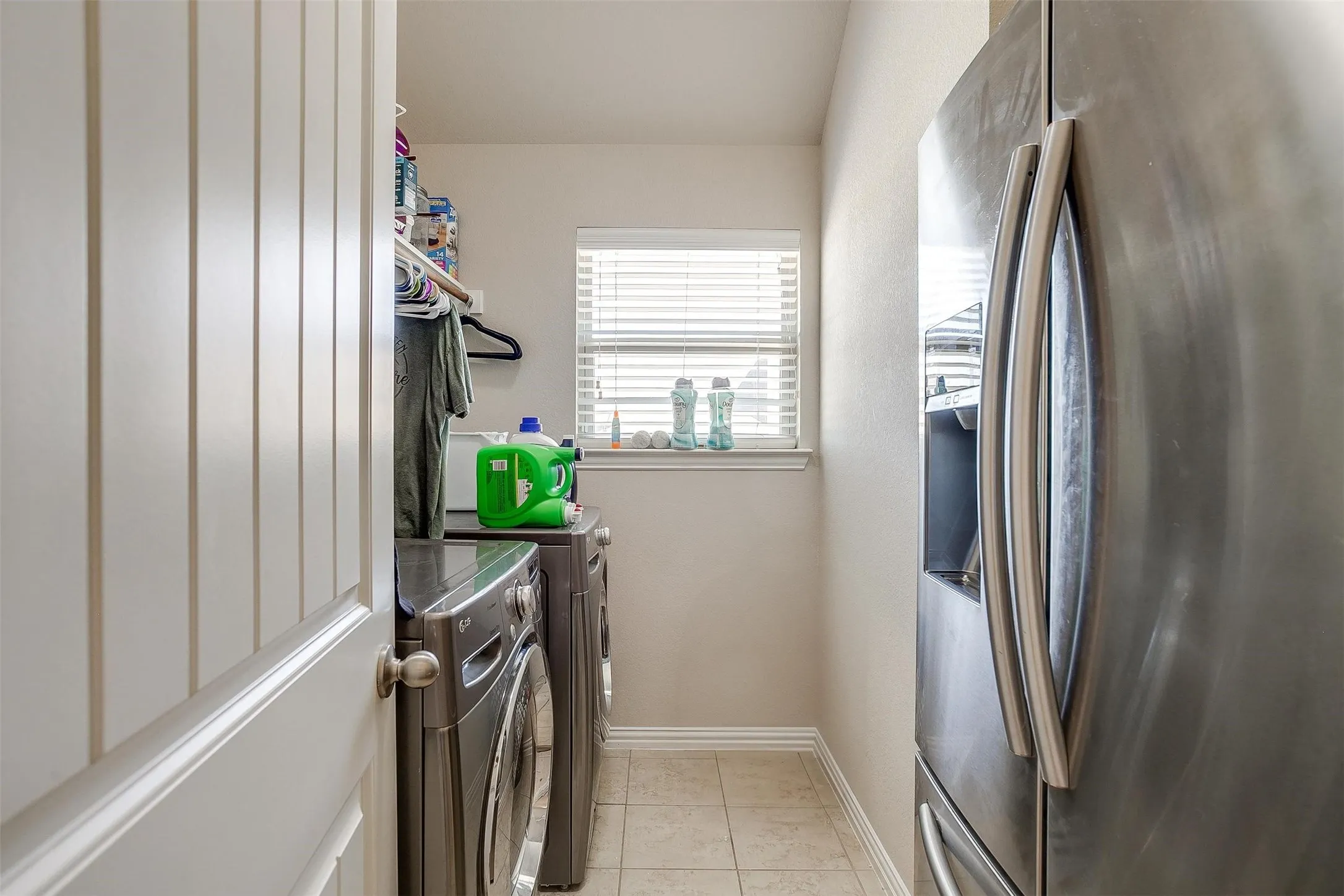 Laundry room featuring light tile patterned floors and separate washer and dryer