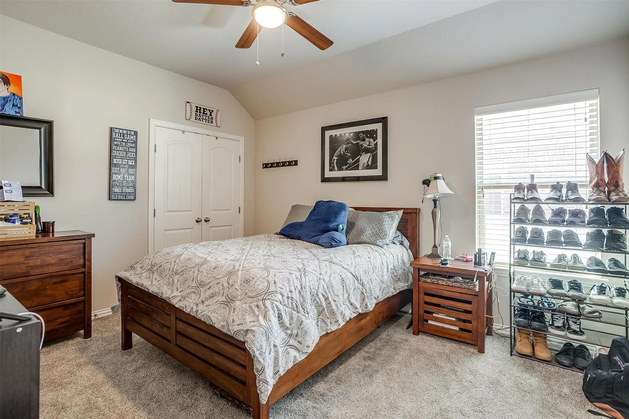 Carpeted bedroom featuring lofted ceiling, a closet, and ceiling fan