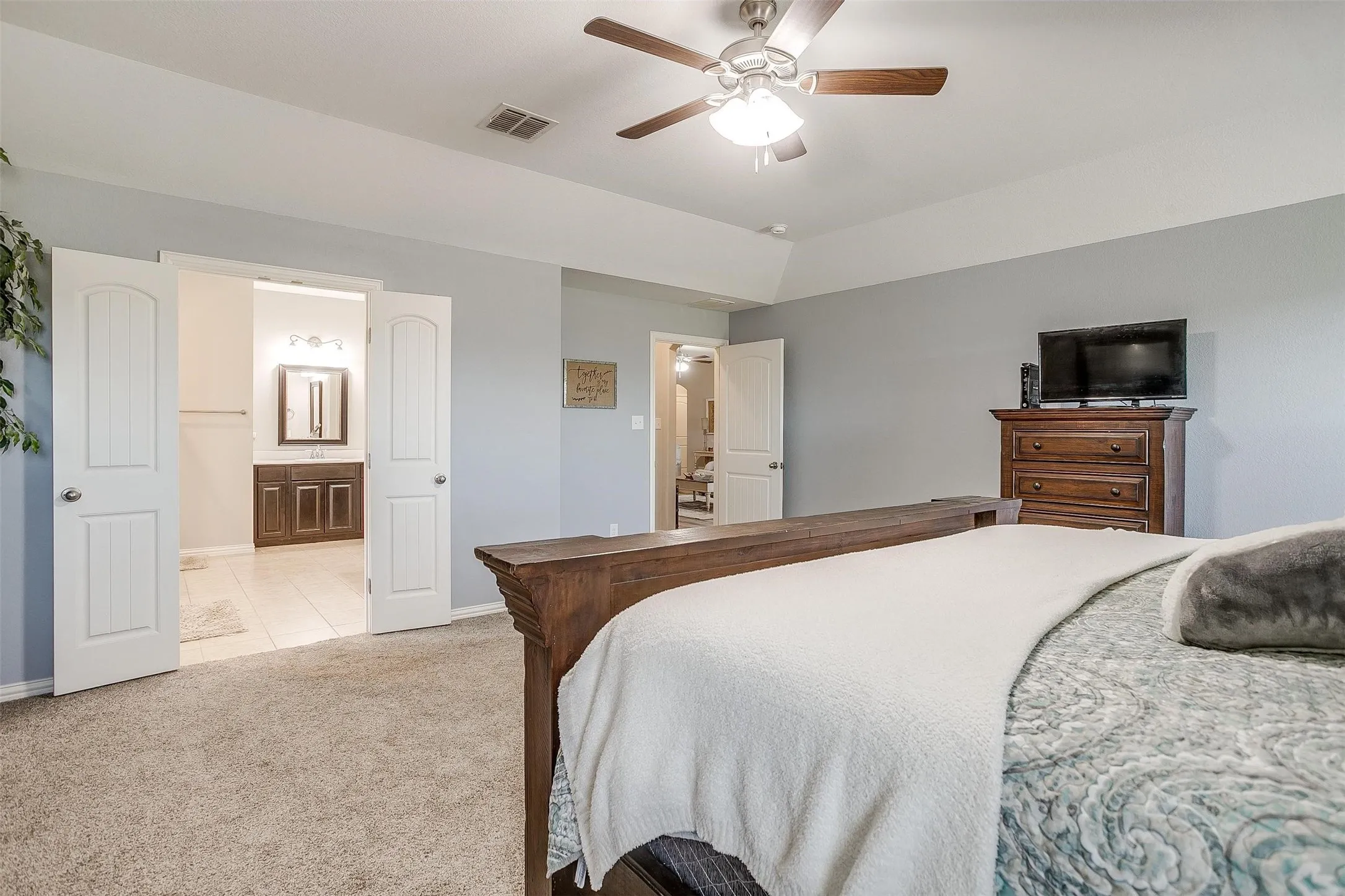Bedroom featuring light carpet, a ceiling fan, and light tile patterned floors