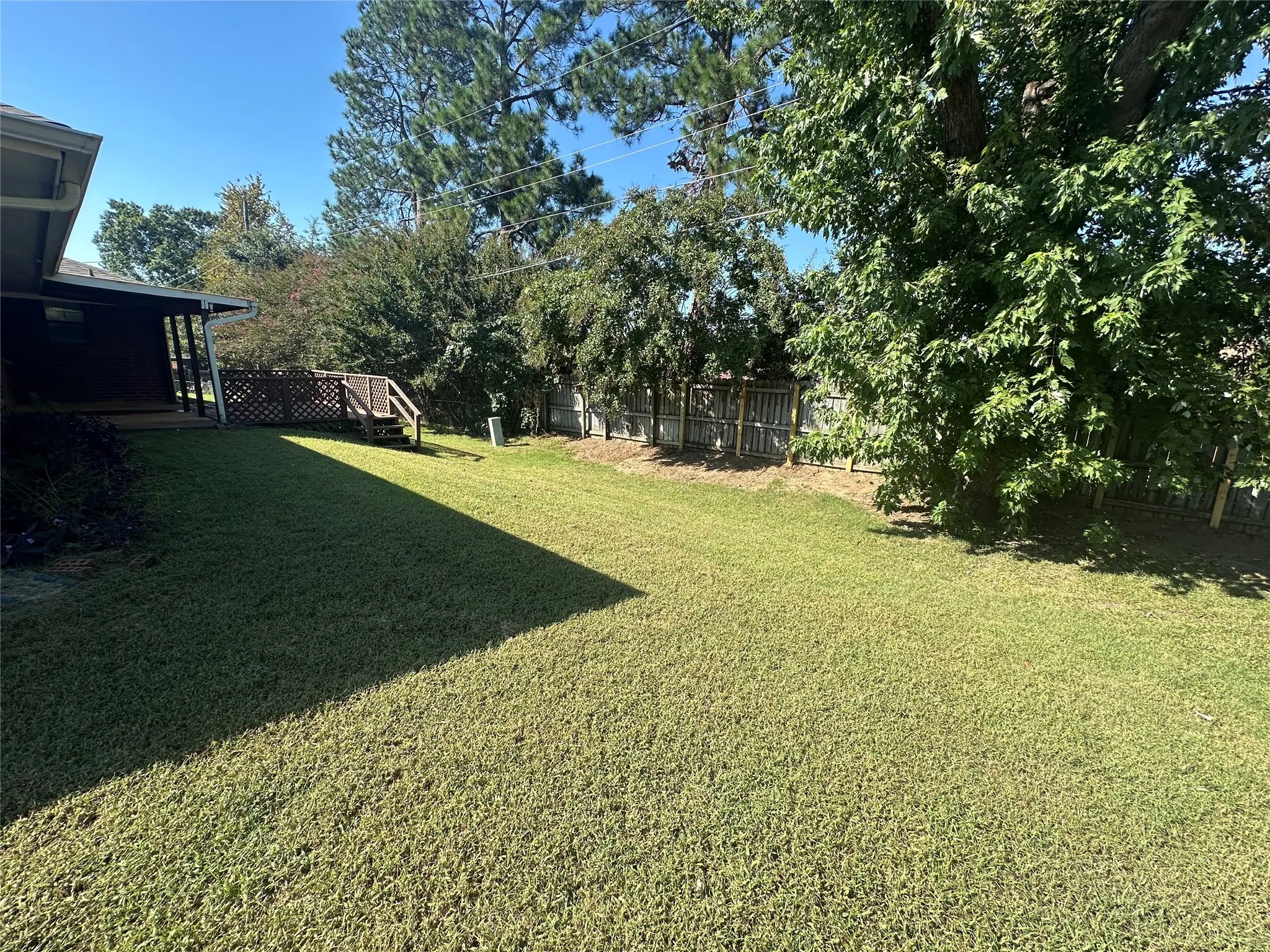 Fenced backyard with a wooden deck