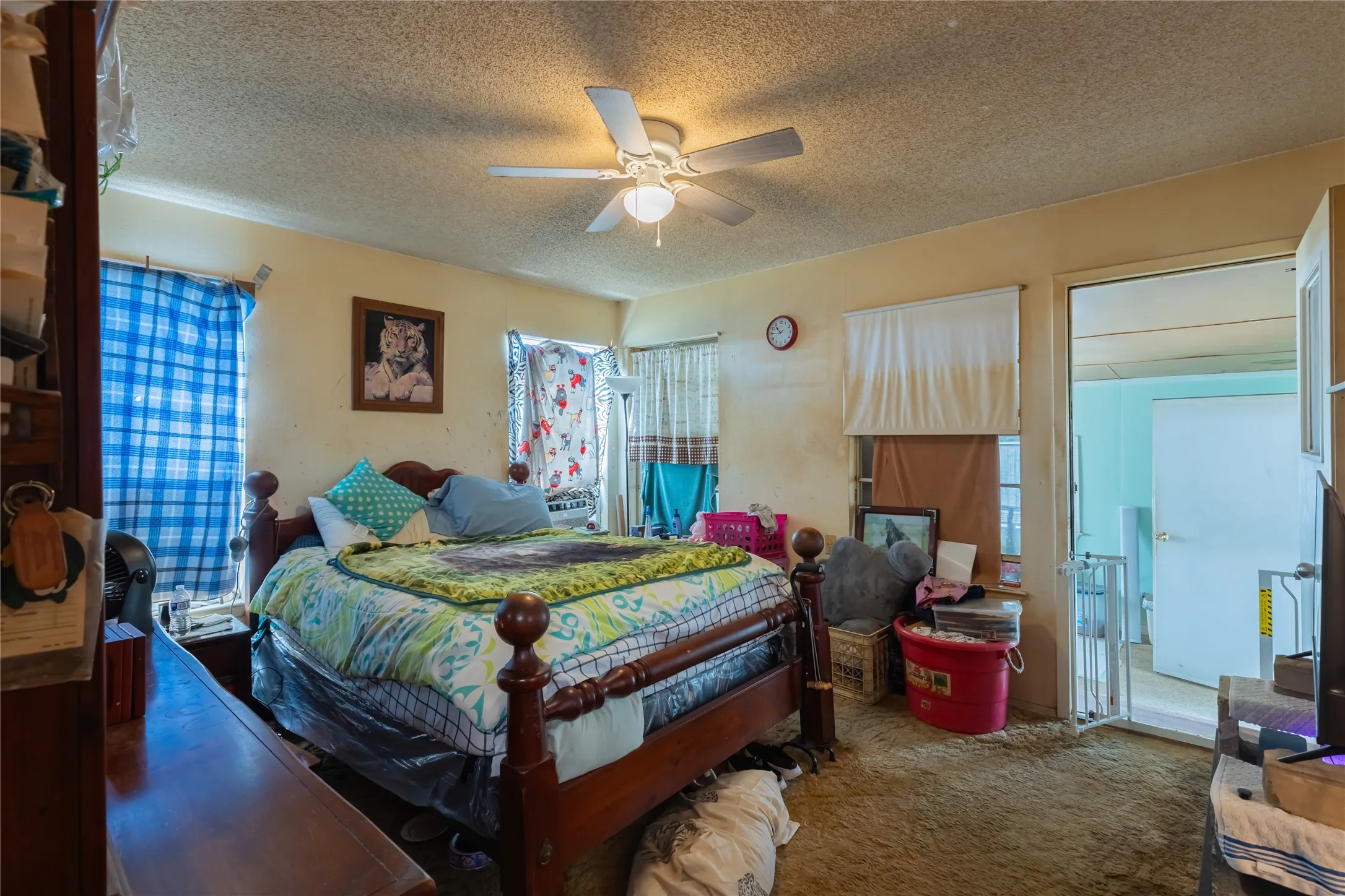 Carpeted bedroom featuring a textured ceiling and ceiling fan