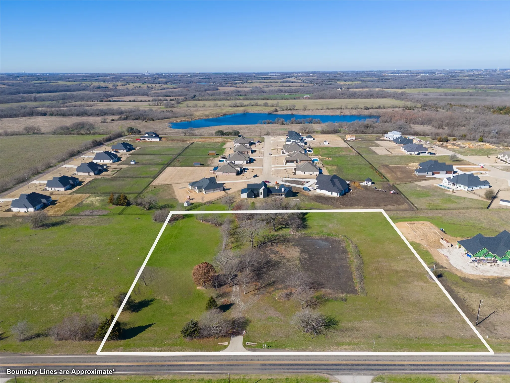 Aerial view of residential area featuring a nearby body of water and property boundaries highlighted