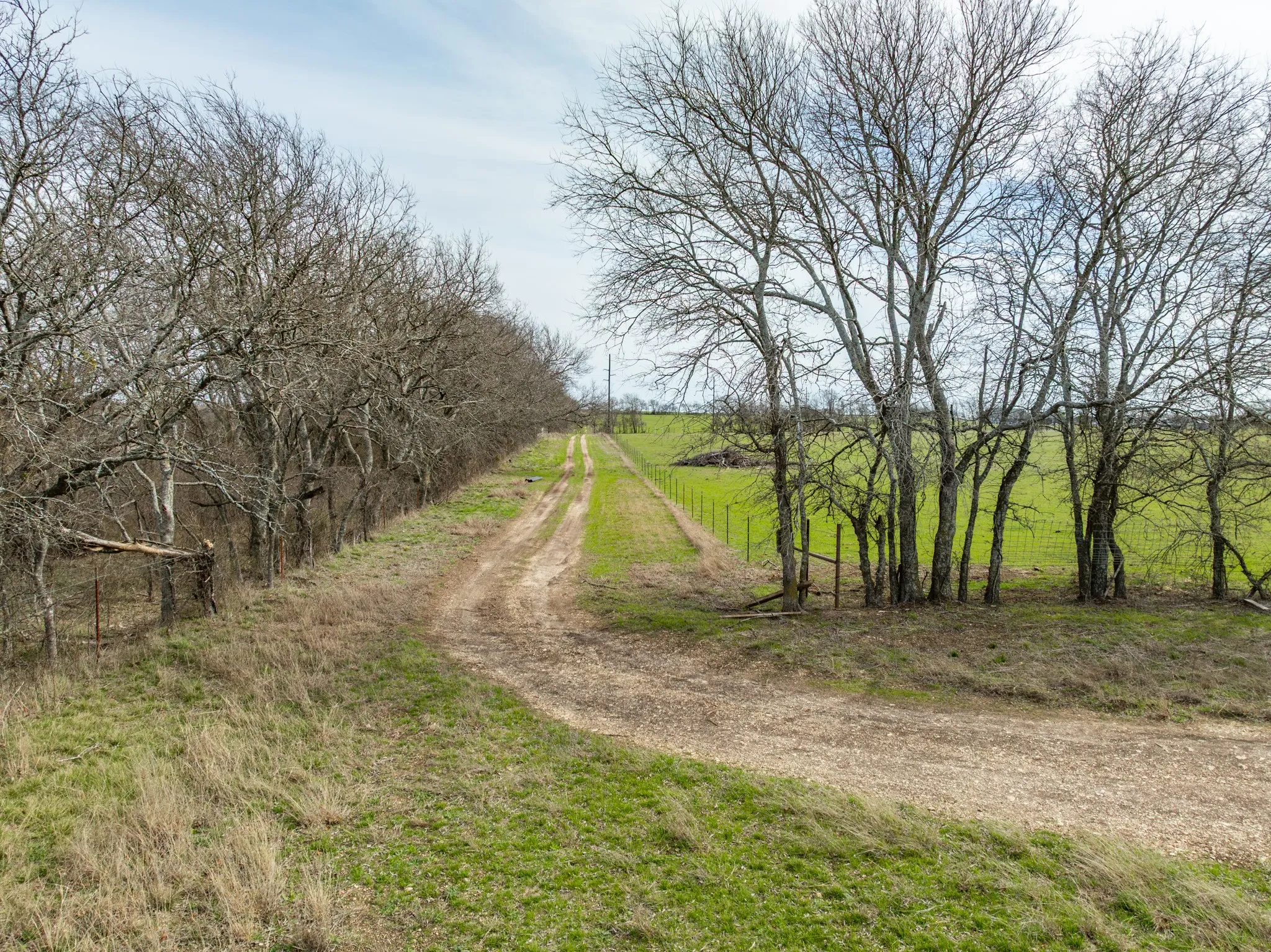 View of dirt / gravel road featuring a view of rural / pastoral area