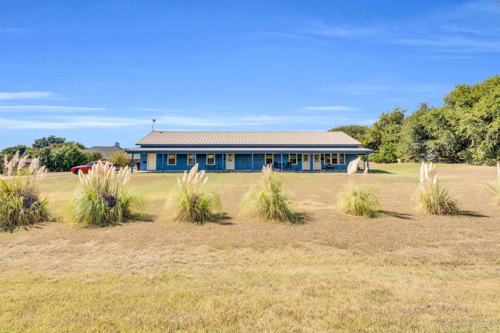 View of front of home featuring a front lawn, a metal roof, and covered porch