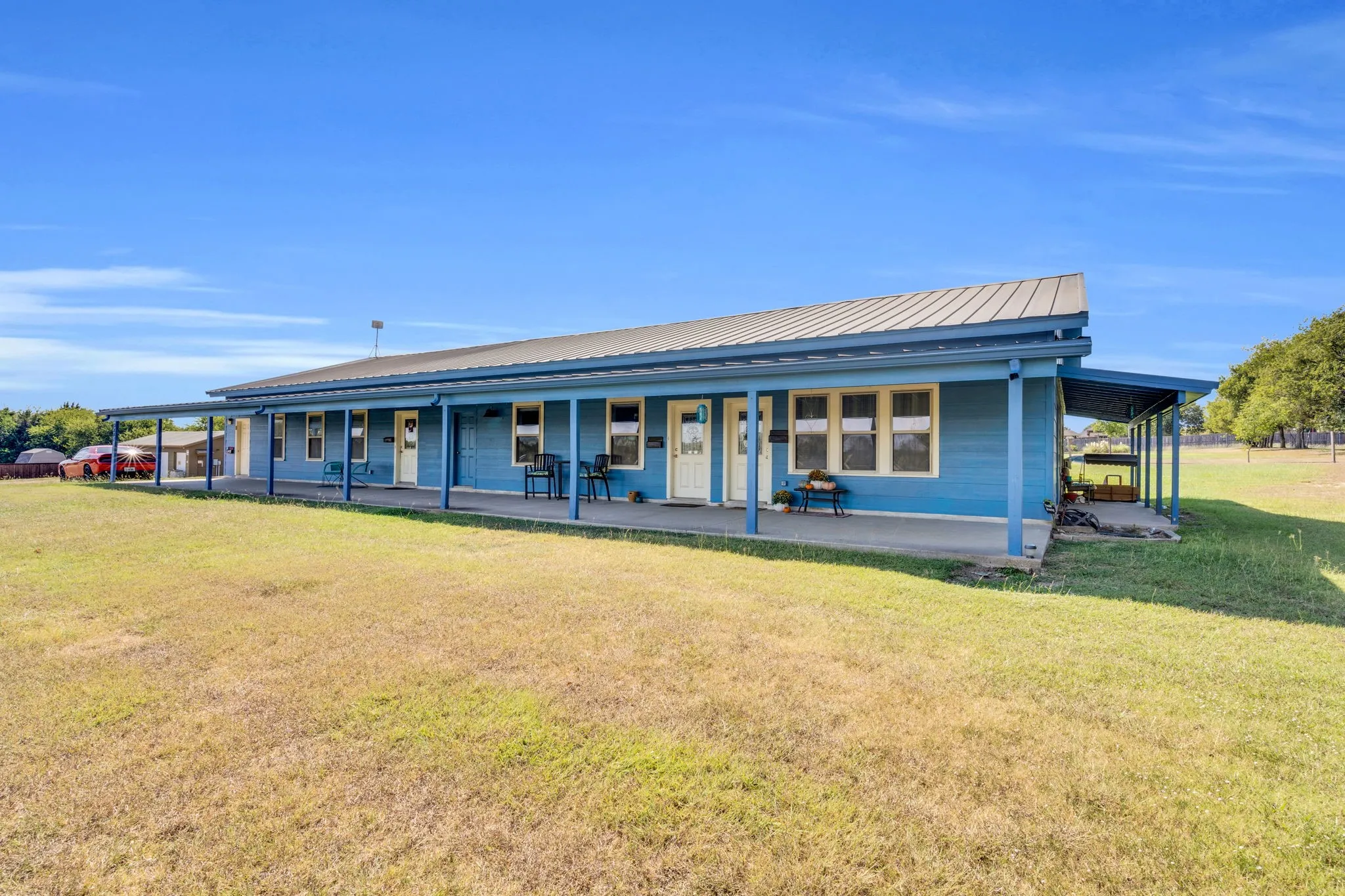 Farmhouse featuring a front lawn, a metal roof, and covered porch