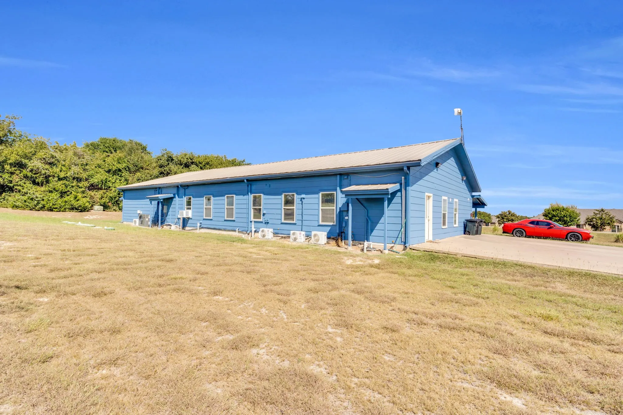 Ranch-style home featuring a front lawn and a metal roof