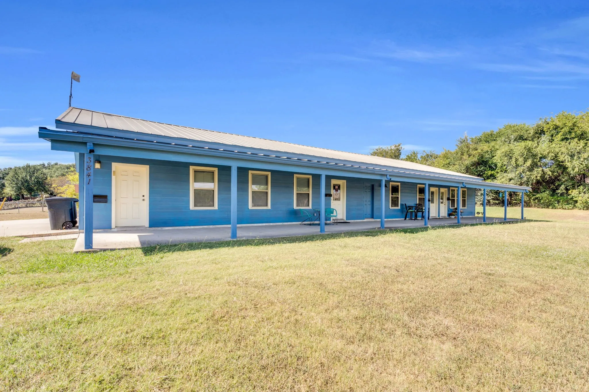 View of front of house with a front lawn, a metal roof, and covered porch